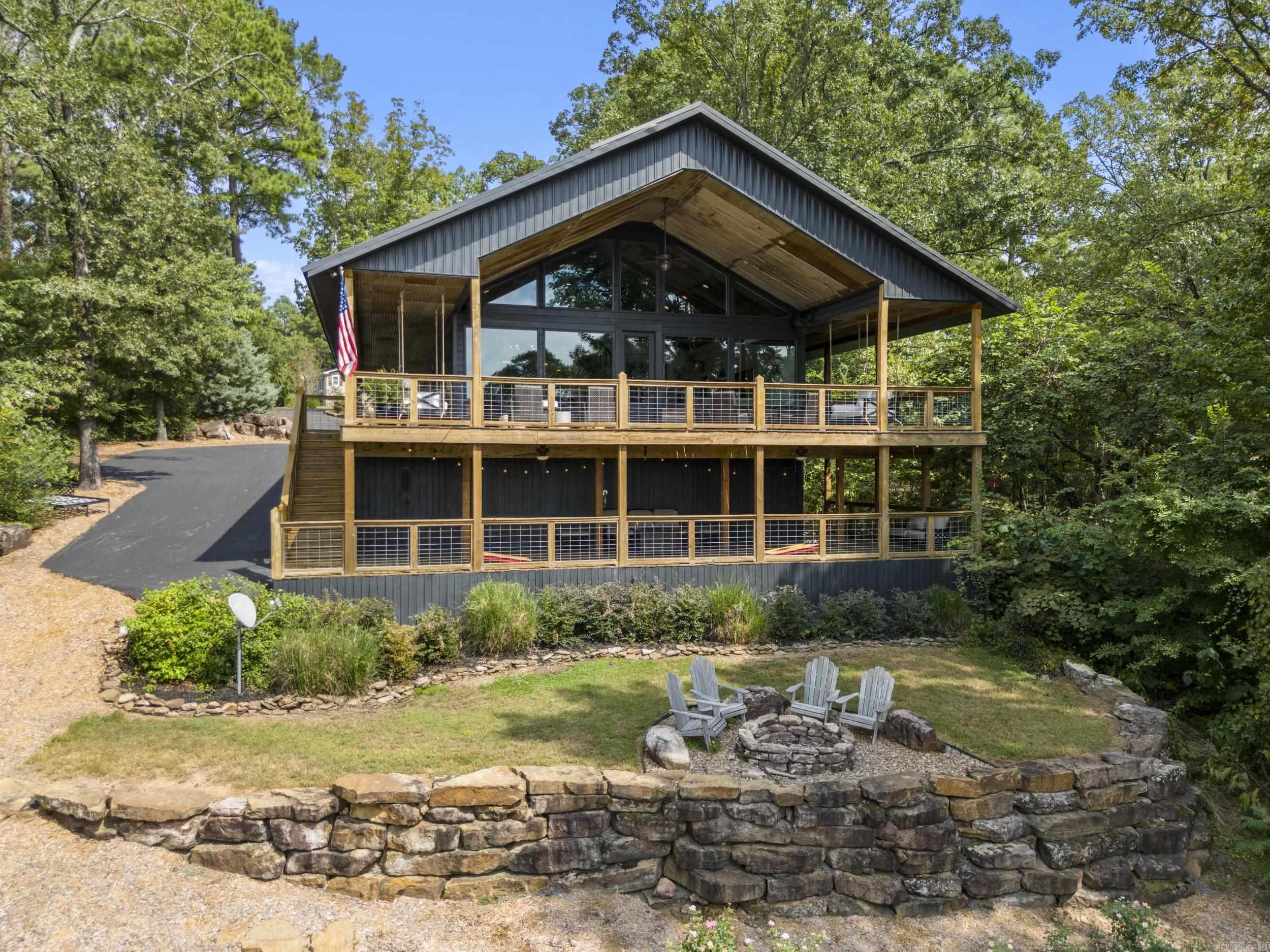 What an amazing location being in the Heart of Greers Ferry Lake near 3 popular Marinas. Sellers had a landscaping company design the rock work, landscaping, & fire pit areas. Double decker with covered deck space on two levels (one side currently being used as a grilling porch on main level). All kitchen appliances stay along with the wine fridge under staircase. Kitchen remodeled in 2023 (New Dishwasher installed) Since the sellers have owned the home, New paint inside and outside, had built-in bunk beds installed, & had laundry room downstairs separated from the full bath (was once combined as one room). Main Level has Primary suite with full bathroom (walk in shower & walk in closet), Guest bedroom, full size hall bathroom, & laundry room. Upstairs has two more bedrooms, game room space, & full bathroom. Low White line providing lake views from the back deck & shoreline where you can pull up a boat. Two back deck speakers stay (Sonos equipment , security cameras, & two porch swing beds do not stay). Sellers currently building another lake house, so furnishings do not stay.