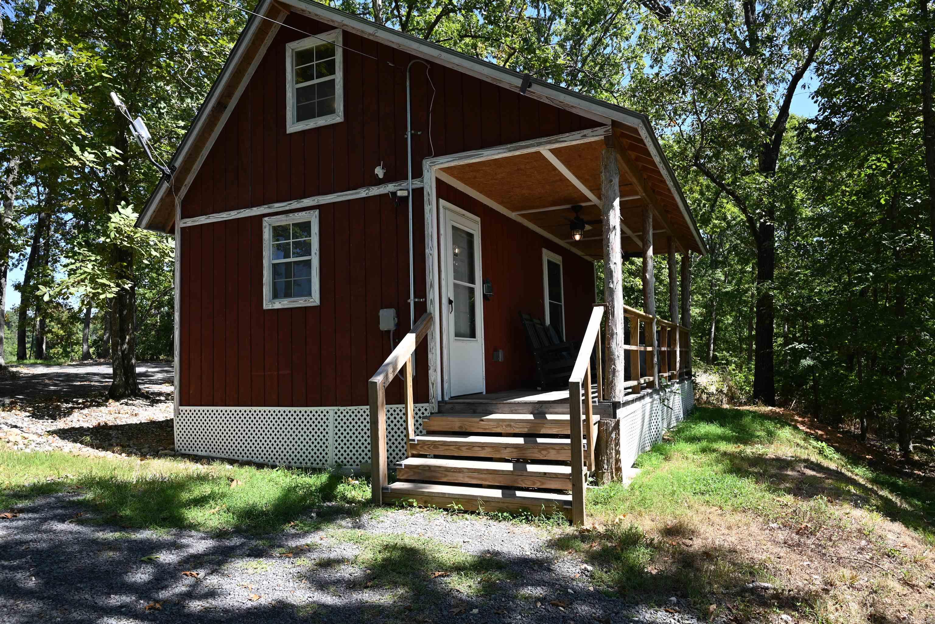 Fully furnished stick-built cabin on approx. 1.75 wooded acres in the heart of the Ozark Mountains! This cozy getaway features a loft bedroom, full bath, living area, washer, dryer, fridge, 2-burner cooktop, toaster oven, and microwave—everything needed for full-time living. Outside, enjoy a hot tub, beautiful pavilion, and a 10’x24’ storage building. Located on a quiet dead-end road with rural water, electric, and septic system in place. Currently a very popular Airbnb known as “Windstorm Cabin,” but also perfect as your own personal “Tiny House.” Enjoy peaceful surroundings, a nice view of distant mountains, and easy access to Branson, MO, the Buffalo National River, White River trout fishing, and 3 major lakes. Only 1.75 miles of dirt road and less than 9 miles to town. A turnkey retreat with income potential or a private escape in the Ozarks!