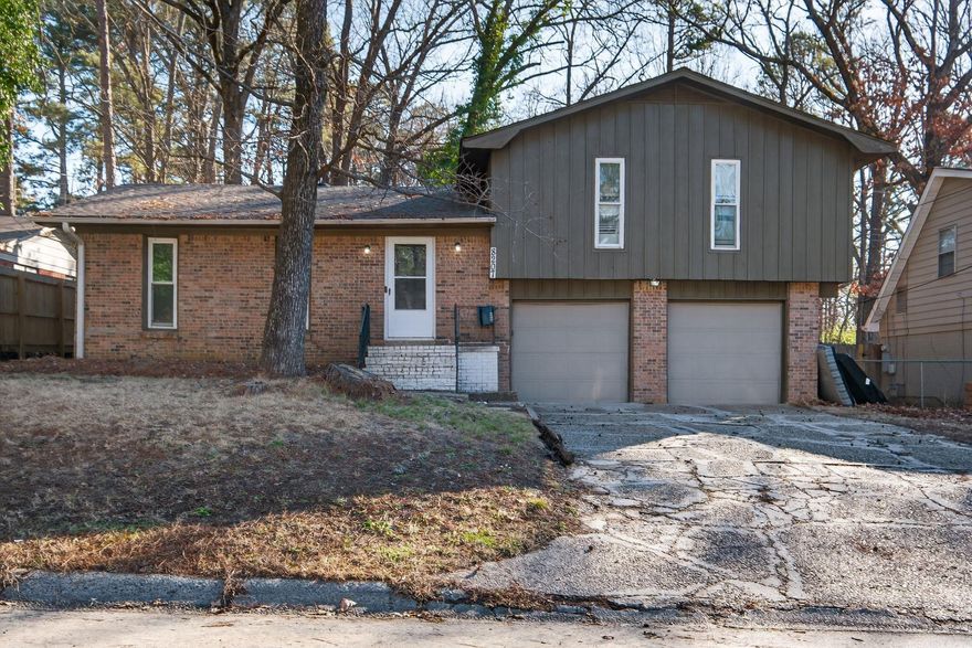 Welcome to 8207 Dreher Lane in Little Rock, Arkansas, a classic split-level brick home offering space, light, and tons of potential. This home features 3 bedrooms and 2 full baths, with a large living room plus an additional spacious family room, perfect for entertaining or relaxing.  Inside, you’ll find neutral colors, abundant natural light, and a cozy brick fireplace that adds warmth and character. The bright kitchen includes a refrigerator, range, and ample cabinet space, making it both functional and inviting. The primary bedroom offers a walk-in closet, and the home includes inside laundry for everyday convenience.  An attached 2-car garage with separate storage rooms provides excellent space for tools, hobbies, or extra belongings. With solid bones, this home simply needs some cleaning and fresh paint to truly shine—an excellent opportunity to make it your own.