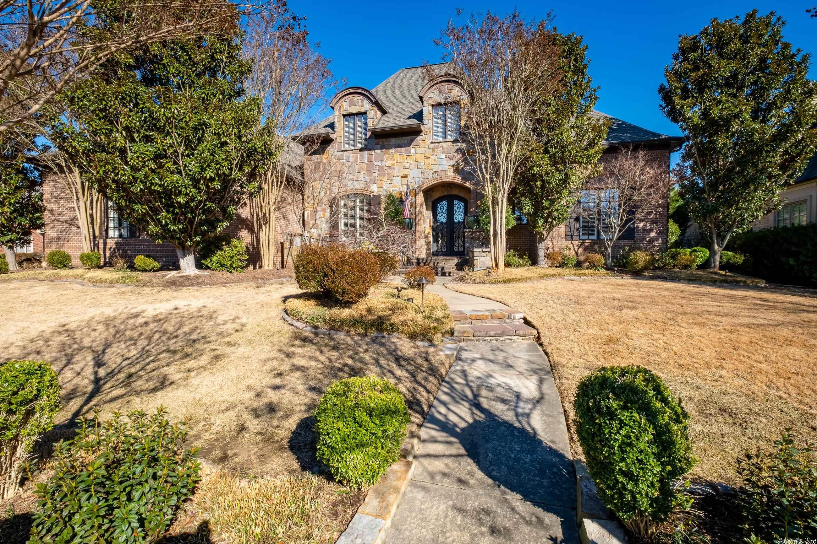 Absolutely beautiful home in fabulous gated Arbors neighborhood in Chenal Valley near the Country Club sits on corner lot for even more privacy. And in The Arbors, the POA maintains your lawn & landscaping for you! 1-owner home built by Mary Jane Herr w very high ceilings, lovely trim & molding, large open rooms, travertine flooring. Dream kit. has 6-burner Viking gas range, tall handsome cabinets, granite island, gorgeous serving/wet bar & opens to charming family room w fireplace & TV hidden by sliding bookshelves. Cozy screened porch w FP added by Carl Gray Henson overlooks wonderful walled patio. Huge primary BR w sitting area down has fantastic bath. 2nd BR down. 2 BRs & a home theater up. 3 car side loading garage. No showings until Monday 3/27