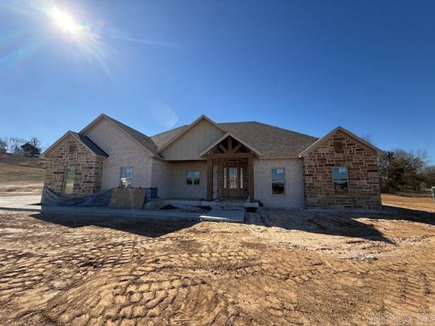 So much curb appeal!! Located on two and a half acres in the Greenbrier School District is this wonderful home with so many extras. Beautiful rock fireplace to match the rock on the exterior of the home.  Abundant cabinetry with a hidden pantry with shelving for all the items that you don't want seen on your countertops. Quartz countertops throughout the home. Enjoy the view from the living room into the private backyard. Fabulous windows at the back of the home let in so much light and show the beautiful view. Coming in from the garage is a half bath with lockers for coats, shoes and bags. You can circle through the laundry room into the primary closet through the bathroom and into the bedroom. You will enjoy the soaking tub and separate shower. By the way, the closet is massive. Very large laundry room with sink and plenty of cabinets. Covered back porch with rock. You will appreciate the storage in this home! Make this home a must see!