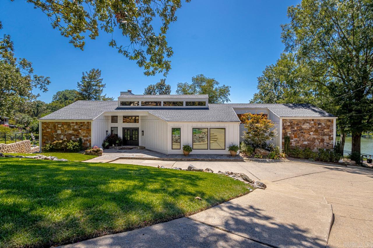 Welcome to 30 E. Lake, this reimagined contemporary classic has beautiful views of lake #2 in Lakewood of North Little Rock. The home has been completely remodeled, featuring 3/4 bedrooms, room downstairs is currently being used as 4 bedroom and has an incredible downstairs entertaining area. 4.5 bathrooms, including a beautiful steam shower and sauna. Open concept with living room, kitchen, and dinning all showing the same beautiful views of the lake. Large windows in the living room reveal abundant natural light. Waterfall island in the kitchen makes for a great entertaining space. An electronic gate allows access to the rear of the property and a two car garage in the rear. A wood composite deck along the entire length of the back of the home so you can enjoy the beautiful lake and it's entirely. This home also features a dock so you can take your boat out of the lake anytime. It doesn't get any better than this...