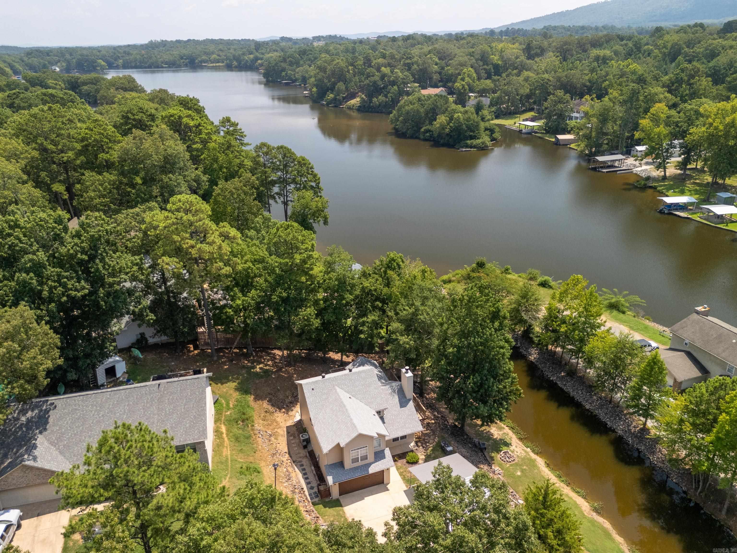 Lake Life Meets Investment Potential on Lake Hamilton! Welcome to your fully furnished lakeside dreamāa beautifully updated 3-bedroom, 2.5-bath retreat nestled on 136 feet of prime Lake Hamilton shoreline! With 2,260 sq ft of living space, this two-story gem offers the ultimate blend of comfort, charm, and opportunity. Whether you're searching for a peaceful getaway or a high-performing short-term rental (no HOA restrictions), this home checks all the boxes. Inside, you'll love the cozy vibes of the intimate family room with a refreshed fireplace and mantel. The sunroom is a true showstopper, offering tranquil lake views that stretch for days. Upstairs, all three spacious bedrooms await, including a generous primary suite with dual walk-in closets. Outside the real magic begins: wrap-around decks surround the home, lakeside fire pit, your own private swim dock with boat tie-up for endless fun on the water. Recent upgrades in 2023 include new architectural shingles & gutter guards, new siding plus added insulation on the north side, stylish new garage door, updated bathrooms, new storm door & blinds throughout, LVP flooring in baths & laundry room.