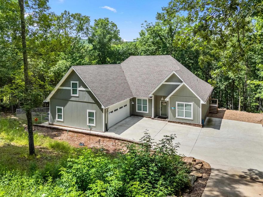 Lakefront living at its finest on Greers Ferry Lake in the beautiful Mystic Isle subdivision. This 4-bedroom, 2.5-bath home offers a perfect blend of modern comfort and retro-inspired style, all set on a cozy, wooded, tree-covered lot just over a half acre with stunning lakefront views and direct access to the water. Inside, you’ll love the inviting living room and bonus room perfect for entertaining or relaxing after a day on the lake. The kitchen is a true standout, featuring a large center island, quartz countertops, custom appliances, abundant cabinetry, a spacious pantry & excellent storage throughout. This home is designed for both function & convenience with a two-car garage plus an additional 16x16 storage area/workshop ideal for lake gear, tools or hobbies. Outside, natural rock landscaping blends beautifully with the wooded surroundings, creating a peaceful & private lakefront setting. Additional highlights include smart-home features: high-speed fiber Wi-Fi, smart thermostat,  garage doors and keypad entry, offering modern efficiency without sacrificing charm. This property delivers the views, access & lifestyle that makes lake living so special.