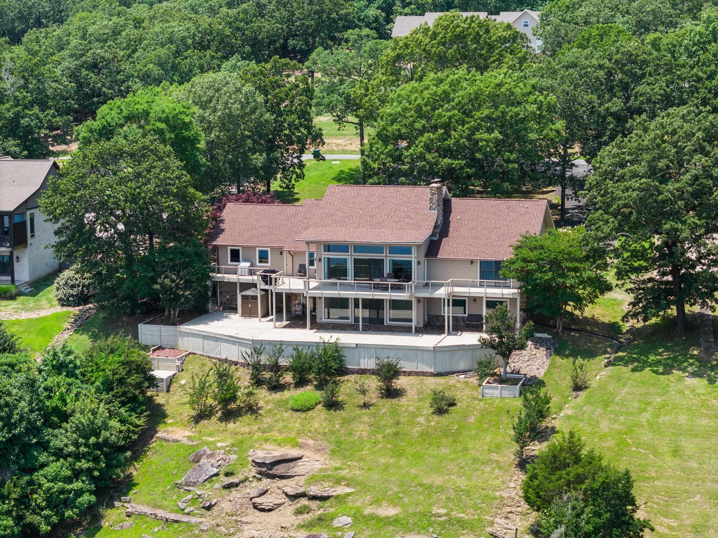 Breathtaking views of Greers Ferry Lake! Spanning over an acre, the lot features extra landscaping that blends seamlessly with the surrounding nature, creating a serene and private oasis. The home itself boasts a newly remodeled kitchen, new roof, new HVACS, panel for generator, porcelain tiled garage equipped with a sink and cabinets, in-ground Rainbird sprinklers, and views everywhere you look. Garage door and thermostat have Wi-Fi control capabilities. Mineral rights convey. Property is getting royalties. Outdoor living is elevated to new heights with two large decks offering stunning lake views, perfect for entertaining or quiet reflection. The presence of tons of wildlife adds to the allure, offering a front-row seat to nature's majesty. This property is not just a home, but a retreat from the everyday, a sanctuary where the wonders of nature meet the pinnacle of comfortable living. Be sure to check out the drone footage and 3D home tour. Make this lake view home yours today!