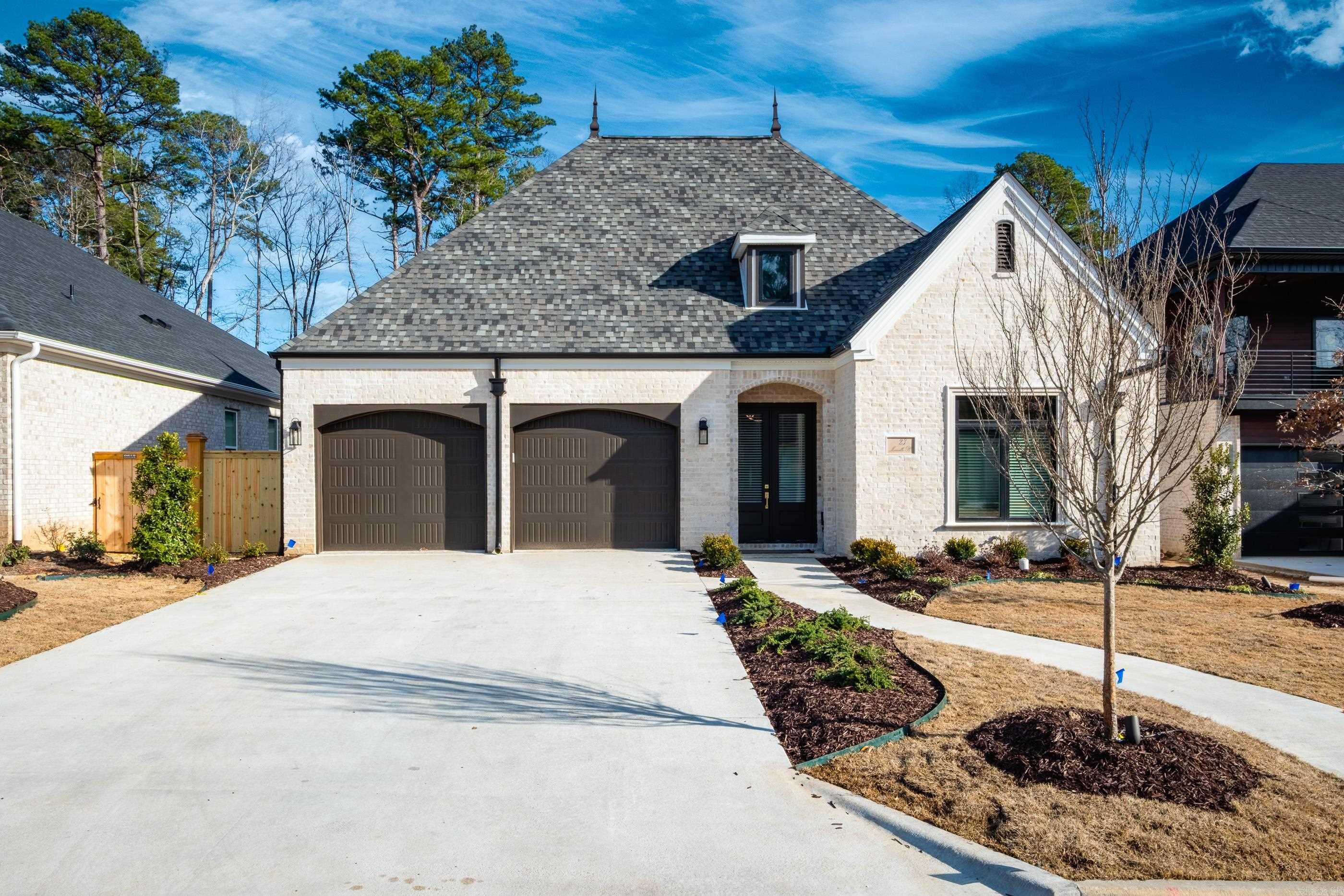 Discover timeless elegance w/ this newly constructed home in the picturesque, gated community of Mereville Pl in Chenal Valley. This luxurious residence exudes high-end craftsmanship & sophisticated design. Enter through a grand foyer w/ soaring 14' ceilings & exquisite golden oak wood floors inlaid w/ tile. The inviting entryway leads to a beautifully appointed dining rm featuring a wet bar, bar fridge, & wine cellar. The spacious family rm, adorned w/ ceiling beams & a fireplace, seamlessly connects to the chef's kitchen. This culinary haven boasts a stunning Quartz breakfast bar, GE stainless steel appliances, & 6-burner gas stove complete w/ pot filler. The primary suite offers a serene retreat w/ a private seating area & a spa-like bathroom. Enjoy the luxury of a dbl vanity, soaking tub, custom-tiled walk-in shower, & designer walk-in closet. The home's living & kitchen areas open to a backyard oasis. The covered patio creates the perfect setting for entertaining family & friends. Addl features include Pella windows, energy-efficient green technology, ceiling speakers & professional landscaping. Situated in a gated community, home offers an added layer of privacy & security.