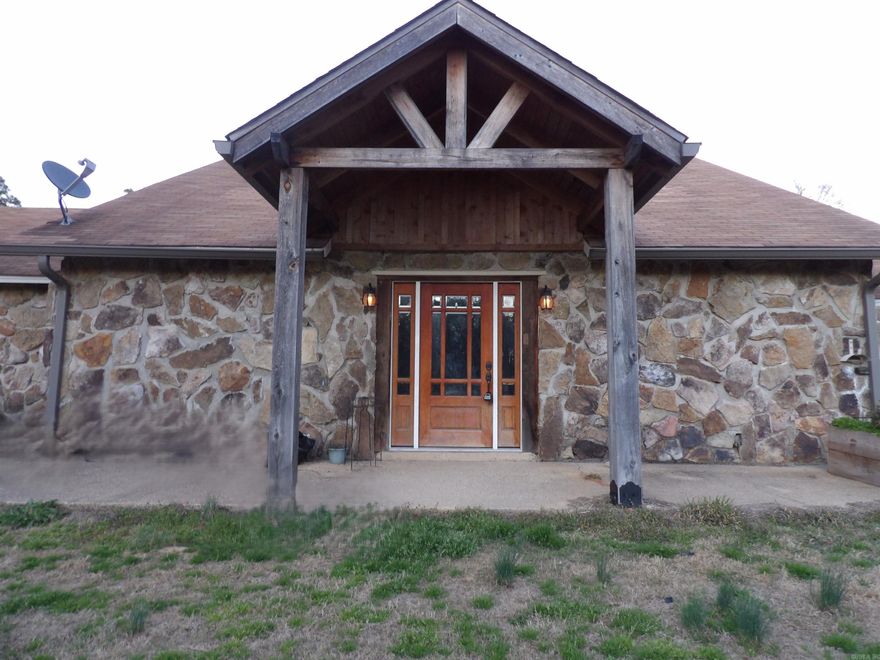 This beautiful home features natural Arkansas stone siding and offers 3 bedrooms, 2 full baths, and a dedicated office area. The spacious kitchen provides abundant dining space, an in-kitchen bar, and plenty of room for gathering. You’ll enjoy both a formal living area and a large den highlighted by a striking stone fireplace. The property includes a nice 30×30 shop with a 16-ft side shed, perfect for equipment, hobbies, or extra storage. A peaceful pond sits at the front of the property, adding charm and curb appeal, while a back balcony gives you a relaxing place to unwind and take in the wooded views. All of this sits on over four acres of rolling hillside, offering privacy, and the feel of true country living.