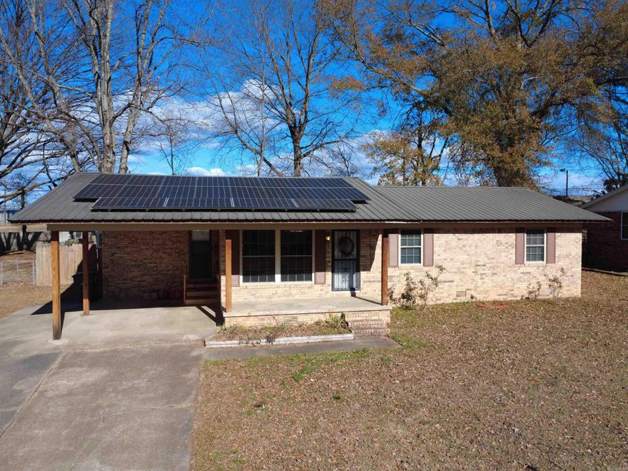 Searcy's Cloverdale Addition is a centrally located and well established neighborhood. This is a very solid home with a metal roof and fully bricked. With a spacious, fully fenced back yard and a 20'x28' deck, the space is set to entertain. An LVL beam has been installed in the living/dining area to open the living space, as well as a large bay window to the front of the home. Replacement vinyl windows, can lighting throughout, and a low threshold walk in shower have all been upgraded in recent years.   24x14 and 26x16 heated and cooled storage buildings convey. 6x8 building previously used as a yard shed also conveys with property.   Trane XB13C HVAC package unit paired with a nest thermostat provides the upmost year round comfort with a 14 SEER efficiency rating.  20 SUNPRO LG375 solar panels. The home has been completely air sealed and winterized by SUNPRO with the EnergyPro Efficiency Package. 25 year workmanship labor warranty, product warranty, and performance warranty. All to be paid in full at closing, set for the new owner to benefit for many years to come.
