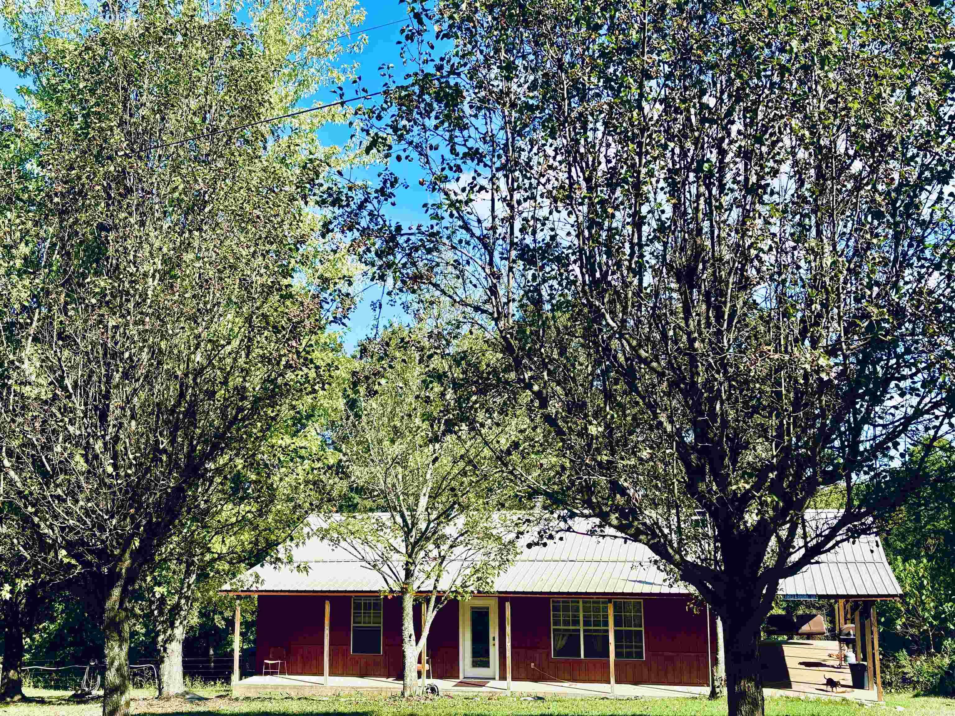 Great price! Move-in ready! This beautiful 2-bedroom, 1 bath, cabin sits on approximately 4 acres with a large detached garage/shop, 16X32 barn with concrete floor and lean-to, and a nice established garden area. The well-designed cabin has an inviting open concept living/kitchen combo with wood ceilings, stainless appliances, wood burning stove, propane wall heater backup heat source, and a large bath/laundry room, Located in the Ozarks just off of paved Trout Farm Road in Searcy County and minutes from world renown Buffalo National River and AR Game and Fish's Howard Hensley Wildlife Management area, this is an ideal location for enjoying the beauty of nature and the outdoors; fishing, hunting, hiking, and horseback/ATV riding to name a few. The spacious covered wrap around porch is one of the cabin's best features with ample space for a private back porch outdoor living area, savoring morning coffee in the porch swing, grilling, or simply quietly watching the sunset or the abundance of white-tail deer and small game. Priced right to sell! Call today for more information or to set up an appointment to view.