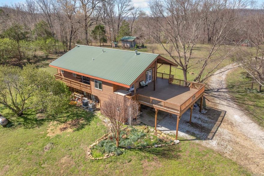 Escape to your country paradise on almost 42 acres of scenic Arkansas countryside. This property offers 2,894 square feet, running waters on two sides, over 900 square feet of front deck for entertaining, multiple insulated outbuildings and a park like setting filled with fruit trees and flowers everywhere. All of this creating a serene landscape year-round. Inside the home you will find two distinct living floors, perfect for multi-generational living or mother-in-law quarters. The centerpiece of the second floor is an Italian imported wood stove that adds style and functionality to the common space. Spacious bedrooms with great windows produce an abundance of natural light for picture perfect views of your surrounding landscape. This property has 4 different outbuildings (totaling 4,715 square feet) providing its new owner with plenty of places to park all of their things along with extra storage for toys and tools that you will need to explore your 42 acre playground.