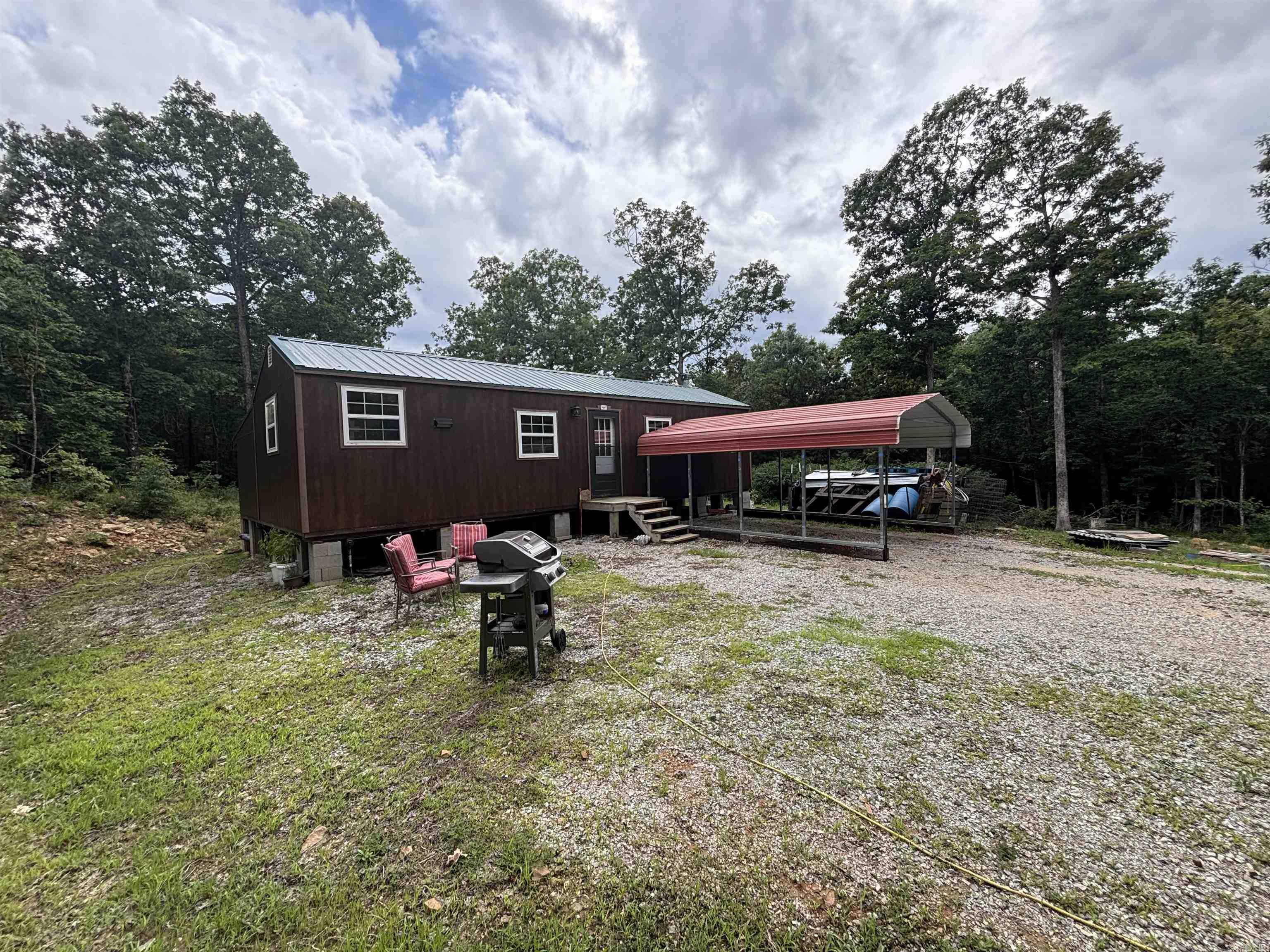 Unique property located just minutes outside of beautiful Mountain View! All the hard work of developing this almost 40-acre tract has already been done for you! Offering not 1, but 2, unfinished structures located in separate private areas; the main cabin is just over 1000 sq ft, has a large 14X40 open concept living/kitchen & could be divided to add a 2nd bedroom, a master w/ his/her walk-in closets, laundry/pantry room, hall to back door & a large bathroom. The 20X20 cabin is nestled down its own driveway surrounded by large shade trees. The mostly wooded acreage has an abundance of whitetail deer, bear, & small game, gorgeous large native stone ledges, walking & ATV trails, & Little Raccoon Creek is only 10 ft from the back property line! There is even an old wagon road & rock wall from decades ago, wet-weather springs, mushrooms, elderberries, & muscadines! Private septic, 4 frost-free water hydrants, 2 public water meters, 50amp RV hookup, generator wired, PEX plumbing, foam insulation, large propane tank, nice new chicken coop, & gravel driveways. The main cabin is fully functionable & currently owner occupied. Finish the dream & make it your own! Call today!