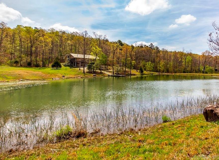 69+/- acres with country home for sale in AR Ozarks. Escape to the tranquil beauty of rural Arkansas with this great acreage. A beautiful country home located on this property boasts 740' of covered porches on 3 sides with 3 sets of stairs. This home overlooks a 1 1/2 acre spring fed pond. The porch is a great place to sit and enjoy your morning coffee and the natural beauty surrounding house. The full basement provides plenty of storage, workshop, bedroom, and utility area. It is a safe haven with 8" reinforced concrete. The upper level has 2 bedrooms and 2 full bathrooms. A nice soapstone wood stove with natural stone surround compliments the living area. The kitchen/dining area has ample space for entertaining family and friends. Central H&A both levels & propane heater in basement. Rural water services the home but there is a well with a 550 gal storage tank in basement. The wooded area provides excellent hunting including turkey, whitetail deer, bear and small game. ATV trails. A wet weather creek runs through the property as well. A 48x36' pole barn provides ample space for your equipment and other storage.  Don't miss this opportunity to make your country dreams come true!