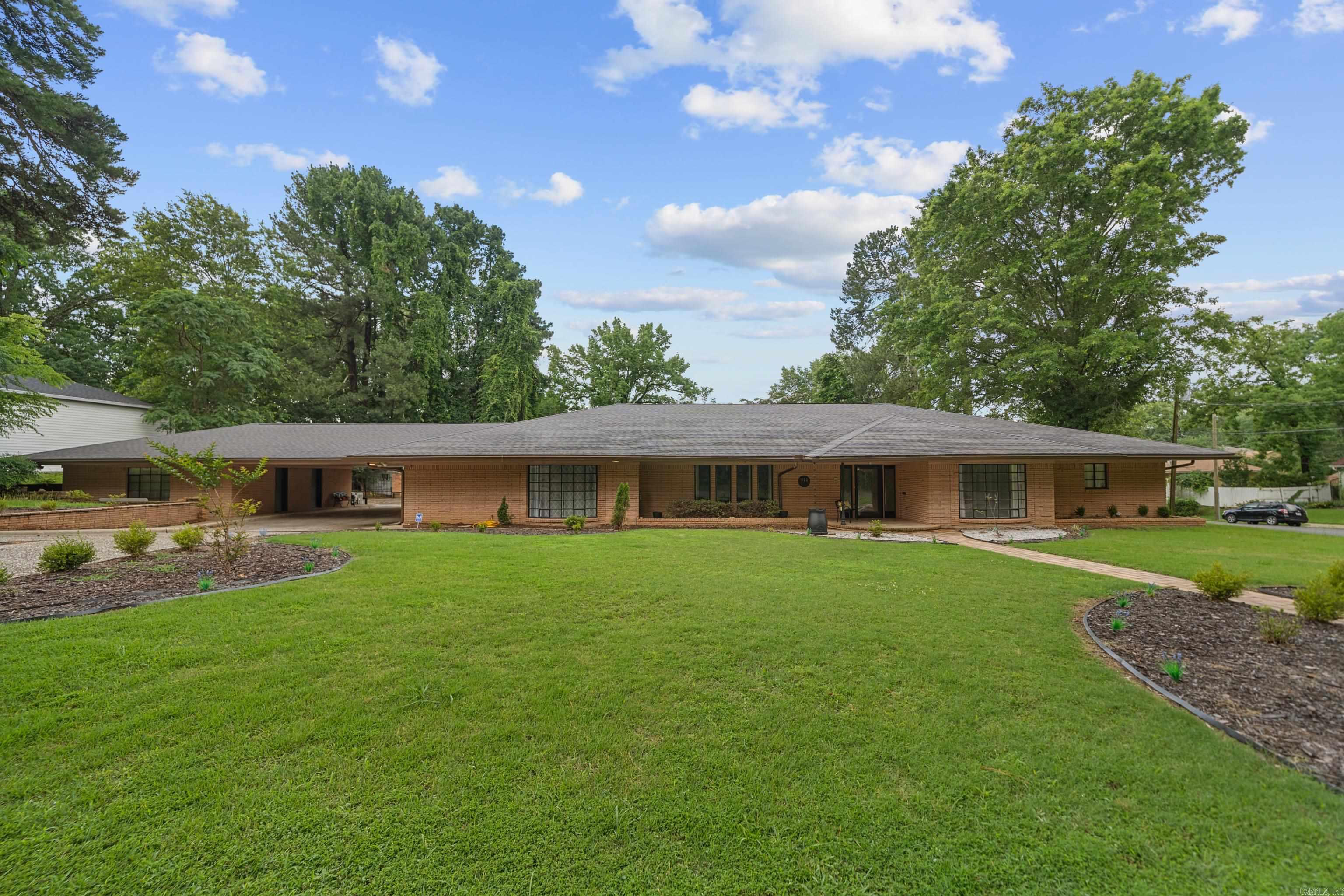 This expansive 5-bedroom, 4.5 bathroom home offers over 5,574 sq ft of living space on a single level, providing ample room for family living and entertaining. Situated on a 0.54-acre lot in a well-established historic neighborhood, the property features a fenced backyard, ideal for outdoor activities. Includes in law quarters/potential rental income unit. The home includes a four-car carport and is conveniently located near downtown Hot Springs, offering easy access to local amenities and attractions. Schedule your showing today!