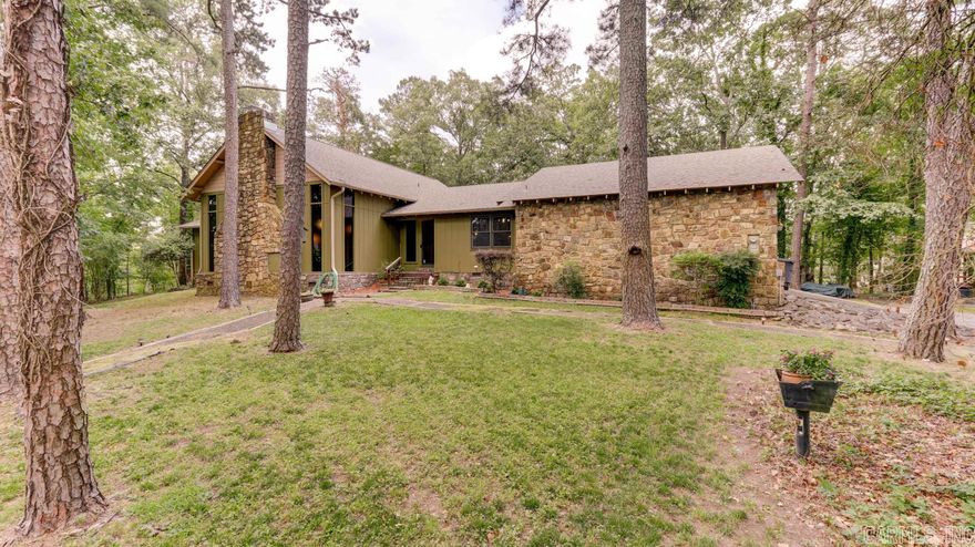 Welcome to this timeless Hot Springs residence, where convenience meets charm! Nestled in a desirable location, this spacious 3 bedroom/2.5 bathroom house offers a comfortable & inviting atmosphere that will make you feel right at home. You'll be captivated by the focal point of the living area—a magnificent, large natural stone fireplace, perfect for cozy evenings & creating lasting memories. The soaring beamed ceilings add a touch of rustic elegance, enhancing the overall character of the space. The kitchen features stunning granite countertops, stainless steel range/oven, trash compactor, dishwasher & pantry closet which make this space a perfect blend of functionality & convenience. The master bedroom awaits you on the main level, complete w/ a private bath, providing for relaxation & privacy. Additionally, two generously-sized guest bedrooms are situated downstairs, offering comfort & convenience for family & friends. These guest bedrooms share a "Jack & Jill" bathroom, providing a practical & functional layout. Venture upstairs to discover the 4th bedroom, which provides flexibility for various needs—whether it be an additional bedroom, a home office, or a hobby room.