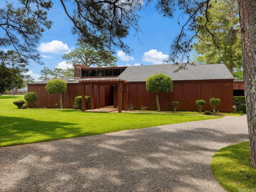 Experience a rare opportunity to own a one-of-a-kind architectural gem designed by Pine Bluff’s own renowned E. Fay Jones. This stunning 3-bedroom, 2.5-bath home is perfectly positioned along the 18th hole of the Pine Bluff Country Club, offering breathtaking golf course views and the opportunity to enjoy the club’s exceptional amenities right from your backyard.  Inside, the home showcases timeless design paired with thoughtful modern updates. The spacious living room is ideal for both relaxing and entertaining, while an additional sitting area provides a cozy retreat. The kitchen features a gas cooktop, convenient breakfast area, and flows effortlessly into the main living spaces. The layout includes a Jack and Jill bedroom setup, perfect for family or guests, along with a generously sized primary suite complete with ample closet space and abundant storage. Every detail reflects the architectural character and craftsmanship that make this home truly special. Located just two miles from Jefferson Regional Medical Center, this property combines convenience, prestige, and scenic beauty, making it a remarkable place to call home.