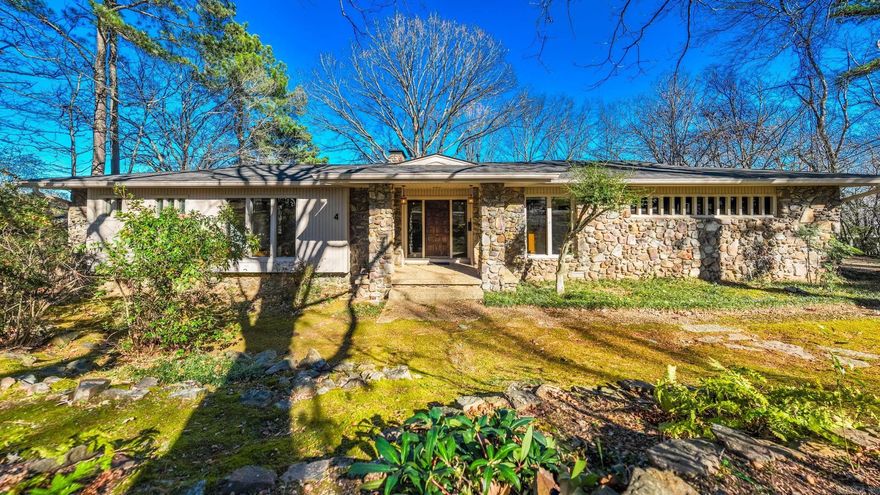 Timeless Mid-Century Modern home with sweeping views of the Arkansas River. The main level offers vaulted ceilings with exposed wood beams, hardwood floors, generous living spaces, and a wall of picture windows overlooking the backyard. A formal dining room features beautiful windows and a see-through fireplace shared with the living area. The gourmet kitchen is spacious with abundant storage, a pantry, and a sunny breakfast room, with an office conveniently located nearby. The primary suite is on the main level and includes a well-appointed bath with walk-in shower and double vanities, along with a main-level half bath. The lower level features four additional bedrooms, two full bathrooms, and a centrally located laundry area. A large deck off the upper living spaces provides the perfect place to enjoy the pretty backyard and river views. Architecturally striking and thoughtfully designed, this one-of-a-kind home offers exceptional character inside and out.This is a jewel you will want to see.