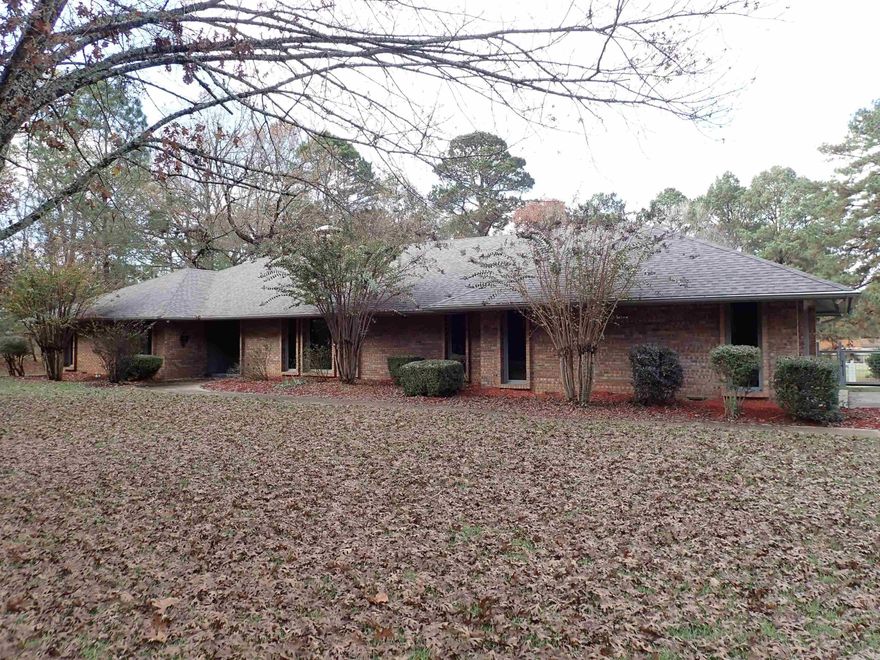 AWESOME QUALITY!  TIMELESS TRADITIONAL/CONTEMPORARY MIX!  Very appealing floorplan --- all on 1-level, approx. 2,786 SQ. FT., centrally heated cooled with 'walk-out' basement shop/storage area (only accessible from the exterior/back yard area).  This residence is ONE OF ARKADELPHIA'S LANDMARK HOMES!  And you have an opportunity to purchase it, now.  How incredible!  S-P-A-C-I-O-U-S interior includes a slate-floored entry hall between the 2 separate living areas and all the bedrooms.  The LIVING ROOM and the separate DINING ROOM 'flow' into each other.  The larger FAMILY ROOM with fireplace and casual 'EVERYDAY' DINING area --- are ALL ONE ROOM with an expansive, VAULTED/BEAMED CEILING and a 'WALL OF WINDOWS (including a quality sliding glass door) opening onto a WIDE, REAR DECK with gorgeous view of the backyard lawn.  There is 'some' fencing along the rear and side boundaries (and along the concrete driveway).  Unusually big double garage! Nice laundry room AND THIRD BATHROOM AREA with adjoining 'walk-in' cedar closet and door to same wide, rear deck.  These areas are adjacent to/nearby the kitchen --- with BOUNTIFUL CABINET SPACE & SUPER ATTRACTIVE 'OVERHEAD LIGHTING' DESIGN!