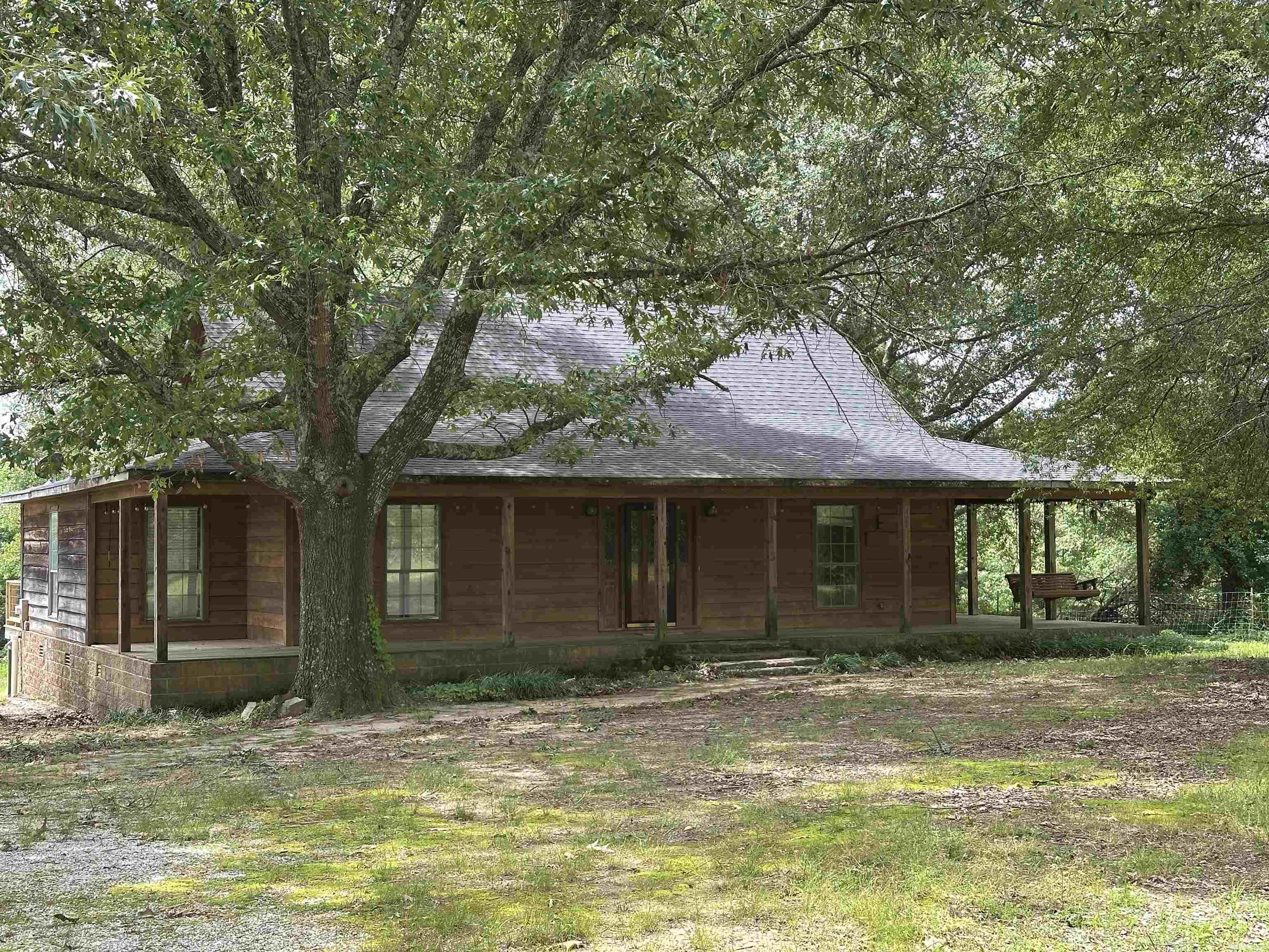 The Farmhouse you've been looking for is on the market in Bismarck! 9.65 acres surrounds this cedar siding home with wrap around front porch and full length rear deck. 3 bed, 2 bath, 1536 sq ft offers an open living/kitchen area, wood flooring, cathedral ceiling, gas logs in the stone fireplace. Bathrooms are roomy and updated. Detached carport/utility shed. Walk in closets. 3rd bedroom could be an office. Plenty of room for a garden area.