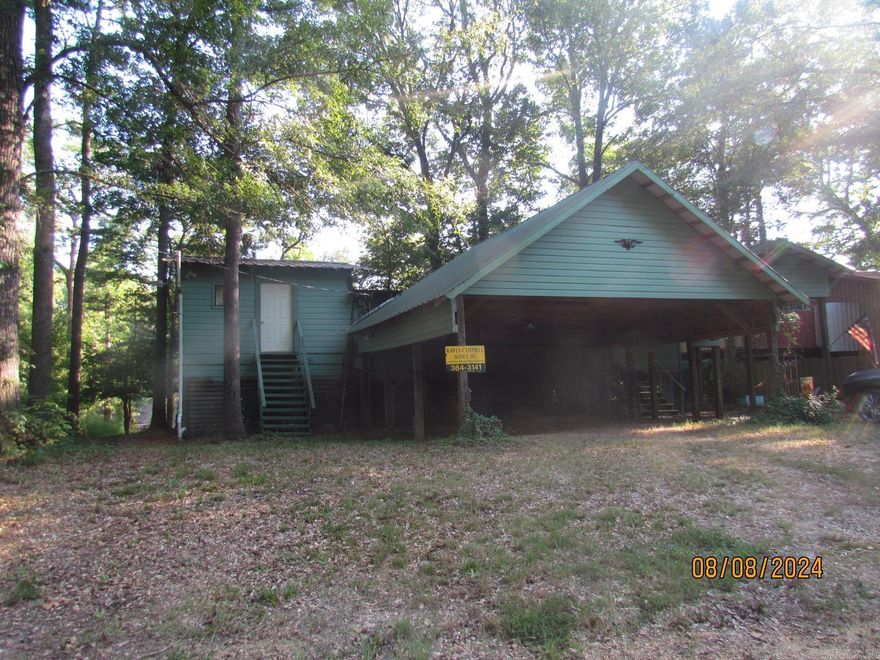 If you desire to live on the Saline river, have a get away on the Saline, this is the property for you.  Located on the North side of the Longview Bridge It is perfect for fishing and boat riding.  It even features the fishing pier and deck, and another deck to have the fish fry that evening.  It also features a screened in back porch with ceiling fans and swing.  Inside the property, the kitchen features a stove, refrigerator, lots of cabinets, pantry, and a bar with stools.  In the living area, it has a wood burning stove, wood laminate floors, dining area with windows surrounding area with beautiful view of the river.  Glass sliding doors lead from the living room to screened porch.  It features 3 bedrooms and two baths, with cedar lined closets.  2 HW heaters, extra storage areas.  A shop is located under the home, and a double carport tall enough for Camper or cook  out area if raining in front.  There is also another covered area with the sign THE LAST RESORT as you enter the property. Home has three window units, ceiling fans, showers in both bathrooms, and most furniture will remain with the property along with bed linens, dishes, etc. Also has new electric box. Must see!!!