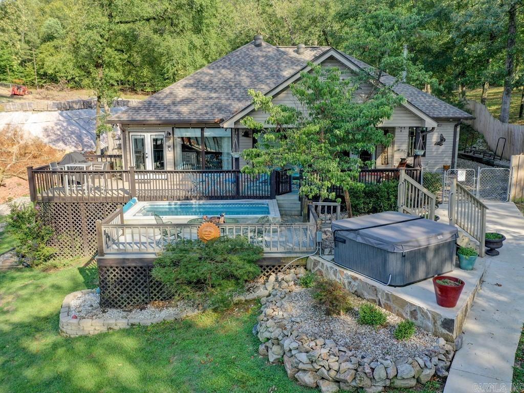 Endless Vacations in store in this beautiful waterfront luxury home with half-acre and 172' of waterfrontage. The main home is 2/2 with modern updated coastal style features, open floor plan, cozy living room with amazing views overlooking Lake Hamilton. The large master suite is both beautiful and relaxing. The Guest House is perfect with 1/1 with a loft offers an open floor plan and updated cozy living. The outdoor living space includes an exercise swim spa and hot tub. At the waters edge is a relaxing area with a beautiful stone fire pit, board walk and deck next to the stationary covered boat stall and swim deck. Enjoy all that Hot Springs has to offer in this amazing waterfront home. Active Airbnb! Call to schedule your private tour of this exquisite property today!