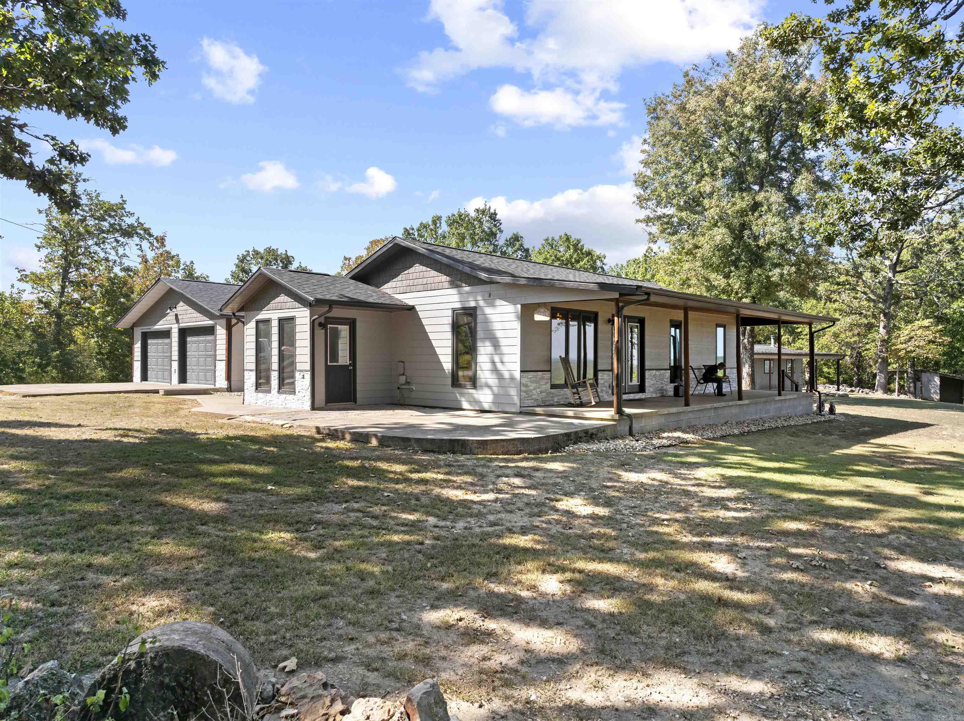 Lakefront living at its finest—with over 800 feet of Corps of Engineers frontage on Bull Shoals Lake setting the stage for your Ozark dream lifestyle. From sunrise coffee on one of three porches to summer evenings on the freshly updated deck, every moment here connects you to the water. This 5-bedroom, 3-bath home has room for everyone, with an oversized family room, perfect for game nights & a basement plumbed for a second kitchen—ideal for a mother-in-law suite or entertainment zone. A safe room offers peace of mind, while a brand-new Generac generator & 500-gallon propane tank keep things running worry-free. Outdoors, the property is built for lake life: a workshop with drive-thru garage, plus dual carports & heated with a woodstove—perfect for year-round projects or storage. Boat slip with lift at Hwy 125 Marina is available with an acceptable offer—making lake days effortless. Abundant wildlife, endless privacy, & direct access to Bull Shoals Lake… this is more than a home, it’s a lifestyle.