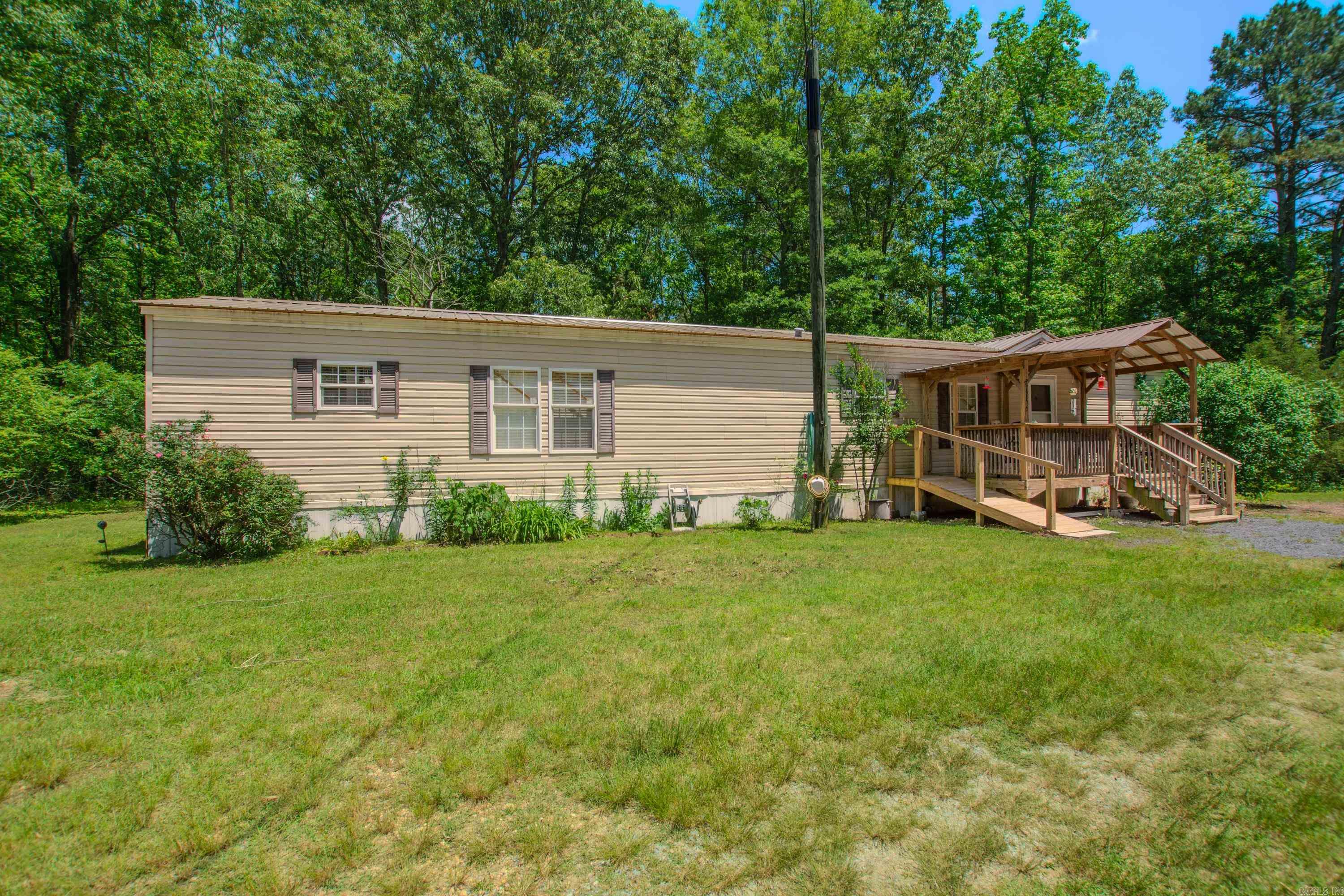 If you are looking for privacy and land to have room to spread out, this is a great place. 3 bd 2 ba mobile home with front and back porches. Spacious kitchen. Large family room open to kitchen and dining. Pantry and laundry combination. Extra slab for 2200 sf home on site. Extra septic. Property is located off South Sardis. Turn at mailbox at sign and drive to back of property. Survey on file.