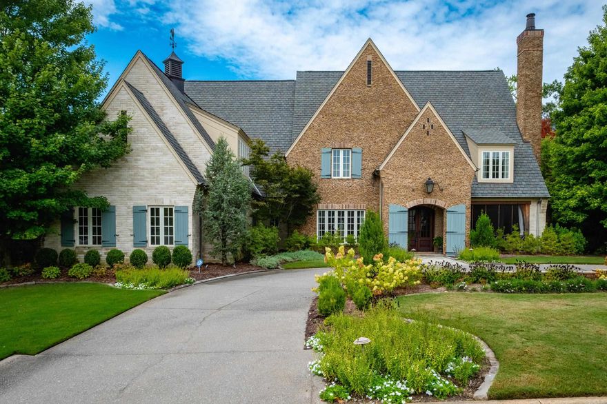 Stunning custom built estate home offering timeless design and modern comfort thru out. Featuring a rock and brick exterior, this residence is rich in character with natural stone and site finished hardwood floors, wood beamed ceilings, and warm, inviting spaces. The great room impresses with a soaring wood vaulted ceiling, wood burning fireplace, and a wall of French doors overlooking the backyard oasis. Formal and informal living areas showcase refined design and functionality. The gourmet kitchen is a showstopper with gorgeous counter space, high end appliances, and a spacious layout open to the hearth room, perfect for everyday living and entertaining. Step onto the covered back deck and enjoy views of the pool with waterfall, stone patio, and lush landscaping. A cozy screened in front patio with a wood burning fireplace extends the outdoor living. The luxurious primary suite includes a spa like bath and huge closet while upstairs offers a media/game room, guest suite, two additional bedrooms, full bath, cedar closet, and a dedicated study/work space. Oversized garages, greenhouse, and green features add to the value while blending beauty and practicality. Much more! Come see.