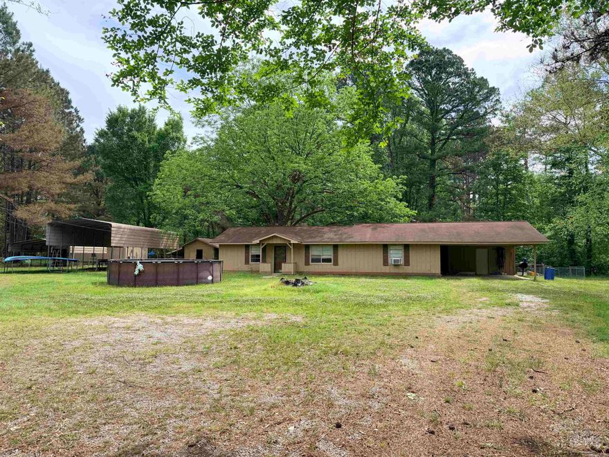 Originally constructed as a 3 bed / 2 bath home, the current owner enclosed the back patio adding on a hallway and (2) 10 x 12 bedrooms. Updated kitchen and new flooring throughout! Large bonus room w/custom panty. Space for wood stove in living room. RV shed and metal carport remain. Fenced-in back yard. Rural location with woods view.  Central heat works but central air does not; currently using window units for cooling. Age of roof is unknown. Property to be sold "as-is."