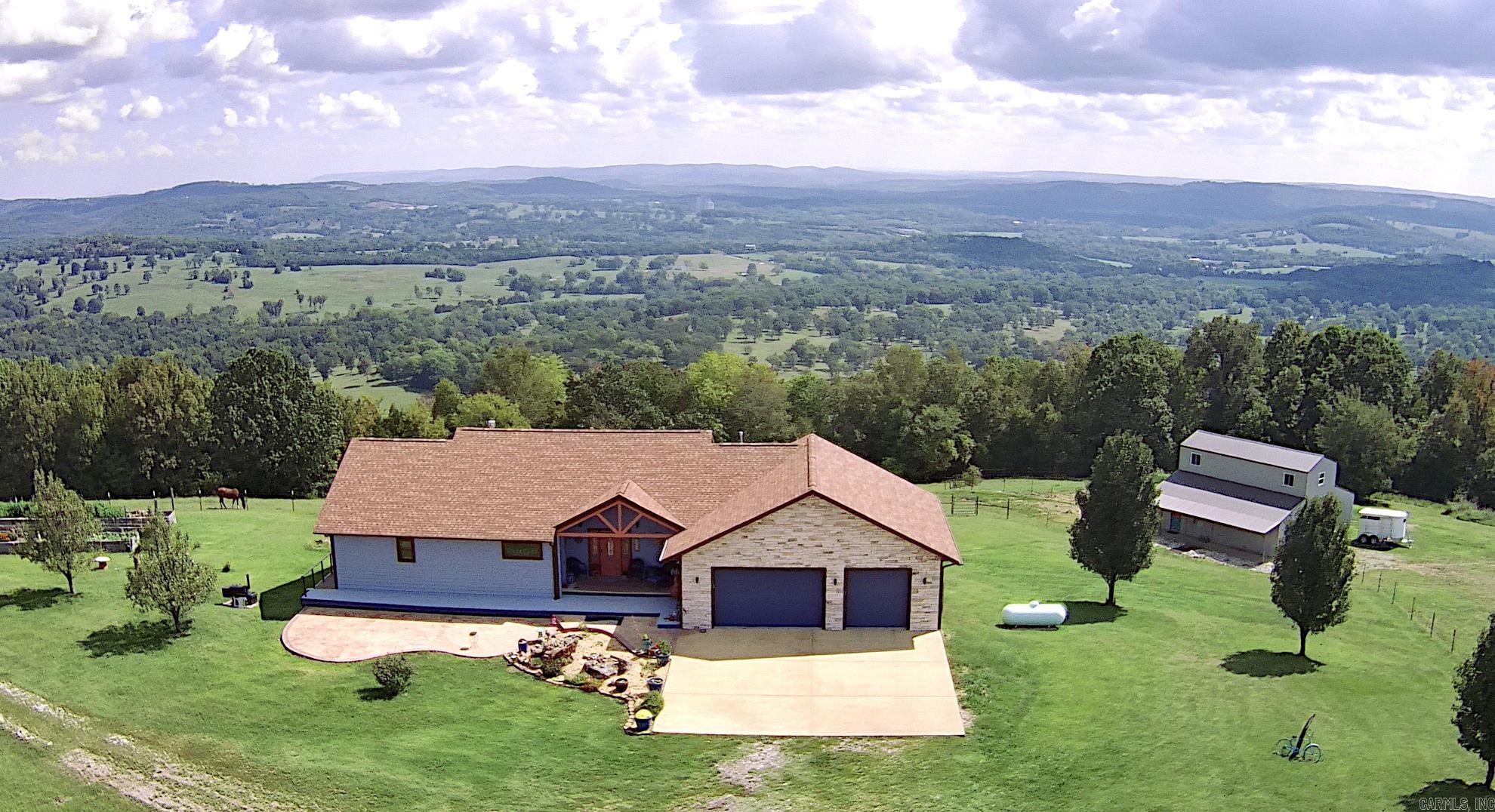 Listed below appraised value! Exceptional property nestled on 31 acres boasting SPECTACULAR views! This contemporary gem offers an airy layout with hickory floors and a dual-sided fireplace. Enjoy views from every room and the expansive master suite. Dive into relaxation with an inviting in-ground pool or unwind on the patio overlooking breathtaking vistas. The walk-out basement is perfect for entertainment, featuring a pool table/game room, additional bedroom, full bath, and office space. A 40'x38' horse barn with tack room (water, electric), run-ins, and a semi-finished loft that would make a great studio! Fenced and cross-fenced pastures, detached 30'x40' shop and raised garden beds. With championship golf courses and world-class fishing nearby, this property is a haven for nature lovers and equestrians alike!