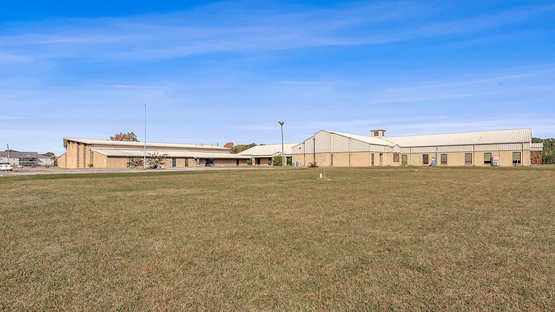 Discover a prime opportunity to own a versatile, expansive facility with over 46,000 square feet of quality space, ideal for education, corporate, or medical use. Situated on 28+/- lush acres, this two-story building offers a full range of amenities, including a large gymnasium with bleachers, a well-stocked library, spacious classrooms, dedicated offices, and a commercial kitchen with an adjacent cafeteria seating area. Designed with convenience and functionality in mind, the property includes a fenced playground, ample concrete parking, a circle drive for easy drop-off and pick-up, and dual entry points for smooth traffic flow. Two additional standalone classroom buildings enhance the flexibility of the layout. Whether you’re looking to expand your institution or launch a new venture, this location is prepared to grow with you, featuring abundant green space for future development. Schedule a tour to explore this exceptional property—ready to support your vision with robust infrastructure and room to thrive.