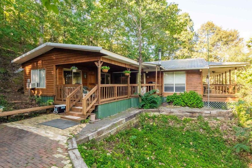 Seeking privacy, seclusion, & a cabin type living feel all while being a short drive to town? Welcome to this hillside home w/a small valley view boasting an updated living room, dine in kitchen, newer granite island, newer granite counters in kitchen, newer kitchen cabinets, appliances, floors, & more! Kitchen has cabinets galore w/a wall mount oven & wall mounted microwave, island located electric oven & stove top, an oversized fridge, & dishwasher. Living Room has vaulted ceilings w/beams projecting a large cabin feel.  Updated the Living Room & Kitchen approx 2017. Just off the Living Rm is the 2023 updated Master Suite w/ ample room for a couch and seating area. 2024 new garage doors hung on the shop w/dual bay doors. Outside living & entertainment w/ample decks overlooking the valley below, storage & update options exist too with a Conex style storage building w/power, plus an antique cooler building (setup as a bunkhouse w/luxury vinyl plank flooring - makes an excellent 2nd bedroom or guests just across the breezeway), portable covered garage, & a large shop w/dual bay doors and more!  Do not miss out on this rare find! PLS NO DRIVE BY VIEWS. APPTS ONLY. SEE AGENT REMARKS.