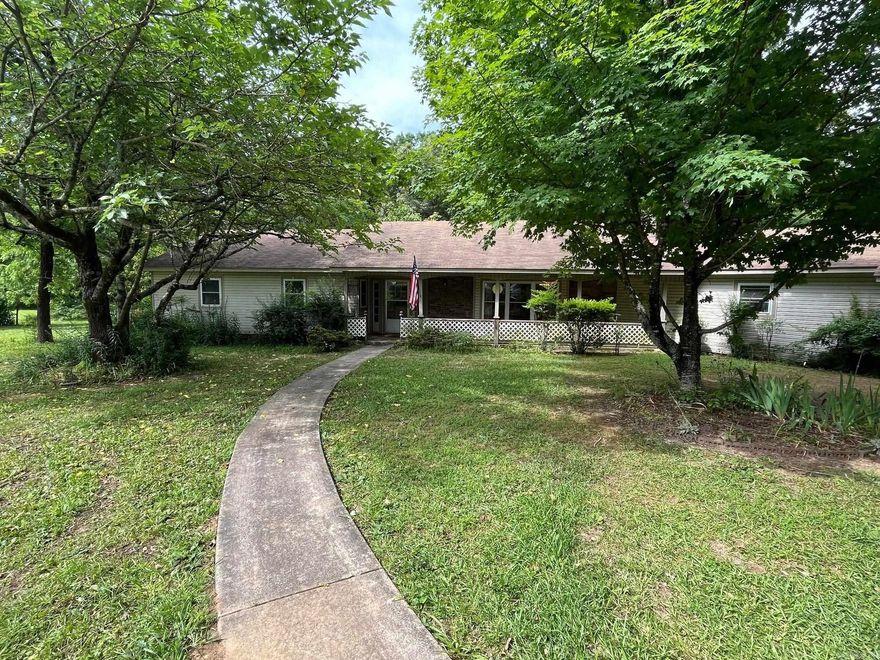 Looking for a SPACIOUS home with acreage and beautiful views? Check out this 3bed/2bath on 6.14 acres in beautiful Rocky, AR! Just 10 mins from Mena, this functional, well-kept home includes a cozy living room with wood fireplace, a large family room, a retro kitchen, a large primary suite with ADA bathroom, ample built in storage, and multiple outdoor seating areas. Sitting on the site of the old Rocky School, this unique property boasts gorgeous foliage and trees planted by the previous owner, and has some interesting historical features such as an old well hand pump, and flag pole marker from the school! Property includes 3 functional out building and a 2 car garage. Relaxation awaits on this special country property! Property being sold as is.