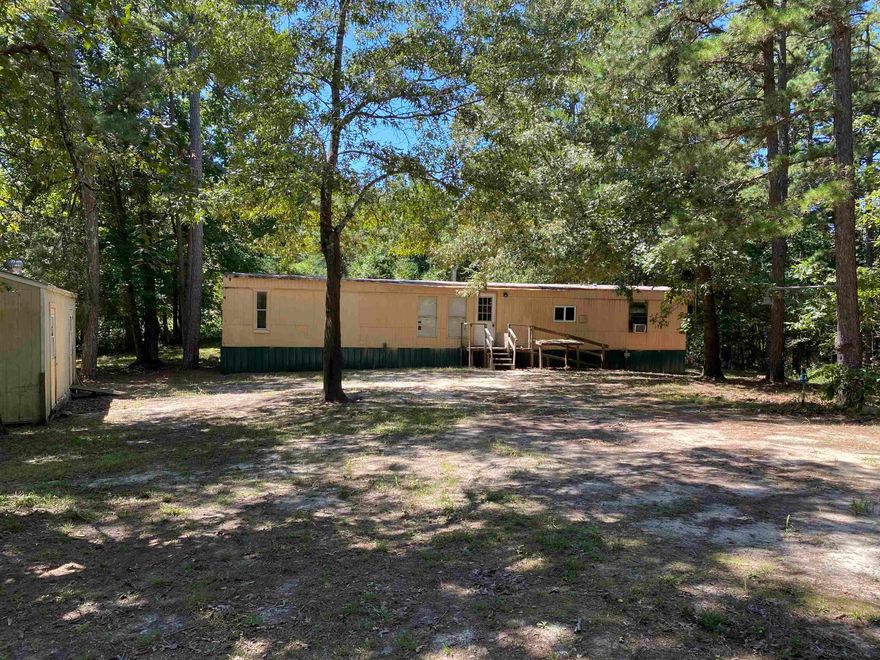 Outside city limits! 2 bedroom 1 bath mobile home on one acre. This spot is secluded, on a dead-end gravel/dirt road. It does have city water and it's all electric. It is plumbed for propane but it's capped off. New flooring throughout. This is an older mobile home but well maintained. Several extras included such as a washing machine, deep freezer, refrigerator, microwave, toaster oven, air fryer & elec stove. 3 window a/c units and 1 portable a/c unit. Electric wall heaters installed 2019. 40 gal elec water heater 2 yrs old. Septic tank 8 yrs old.  Also included is a 12x24 storage building with electric.  Coop electric & Next internet provider. This is a great opportunity for a cash buyer to set up a homestead. This type property is in high demand so act fast and call us today!