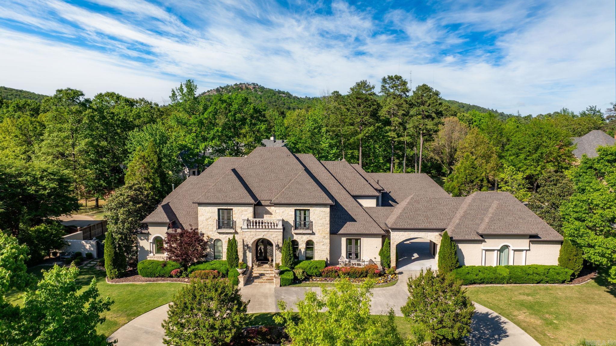 Spectacular Chenal Valley home located on premier corner lot in beautiful Sologne. Handsome exterior is made from Texas limestone and brick with stunning interior decor. Fabulous floor plan and exquisite amenities make it the ultimate setting for family living and entertaining. Elegant formal dining and spacious family room with fireplace and access to covered terrace. Gourmet kitchen with top of the line appliances and custom cabinetry. Home office/Study and Media room. In addition the main level features luxurious, spa inspired primary suite along with guest suite. The upper level consist of 3 bedroom suites and 2 living areas. Lush landscape with outliving spaces including gorgeous pool for outdoor entertaining. Four car garage. Gated neighborhood.