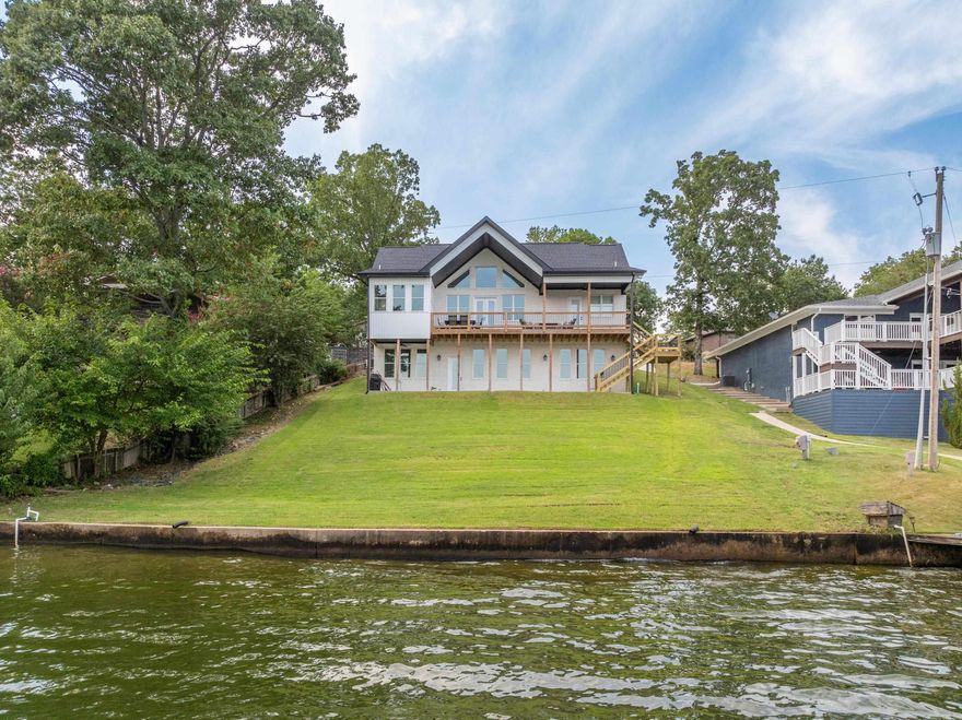 Experience the ultimate in luxury living with this stunning custom-built 5-bedroom, 5-bathroom lake house on the beautiful shores of Lake Hamilton. Spanning 3,500 square feet, this home offers an exquisite blend of comfort, style, and breathtaking views. The primary bedroom is conveniently located on the main level, offering unparalleled views of the serene lake. Wake up each morning to the beauty of the water, and enjoy the convenience of an en-suite bathroom, providing both privacy and luxury. Each of the five spacious bedrooms in this home comes with its own dedicated bathroom, ensuring comfort and convenience for every resident and guest. This thoughtful design makes it an ideal choice for either a primary residence or a highly desirable short-term rental property. he expansive 10x42covered deck is perfect for entertaining, with plenty of space for outdoor dining, lounging, or simply enjoying the magnificent views of Lake Hamilton’s main channel. Whether hosting a summer BBQ or a quiet evening under the stars, this outdoor space is sure to impress. At the heart of this home is a top-of-the-line kitchen, equipped with premium appliances and finishes.