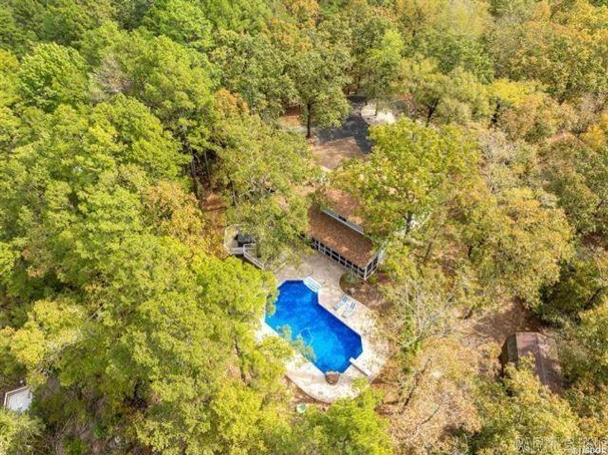 This exceptional property offers the perfect blend of privacy and luxury, boasting 2.78 acres of serene lakefront living with 100 ft of pristine shoreline. Enjoy the convenience of a floating covered boat slip, ideal for water enthusiasts. The main residence spans 2,423sq. ft., featuring 3 spacious bedrooms, 3.5 baths, and an office. It comfortably accommodates up to 8 guests, making it perfect for family gathering or entertaining. The charming guest house offers 880 sq. ft. of cozy living space, with 1 bedroom, 1 bath, and a sunroom that sleep up to 4 guests. Currently operating as an Airbnb, this property offers an income stream, with the potential to continue as a rental or to be enjoyed as a private residence. With no restrictions on the property, you also have the option to build an additional small home, adding even more possibilities to this stunning estate. Outdoors, you’ll find an inground pool, hot tub, and firepit—perfect for enjoying the beauty of the outdoors. From this prime location, you’ll also have a front-row seat to the spectacular fireworks displays over Ouachita and Hamilton, as well as breathtaking mountain and lake views. This property has been thoughtfully