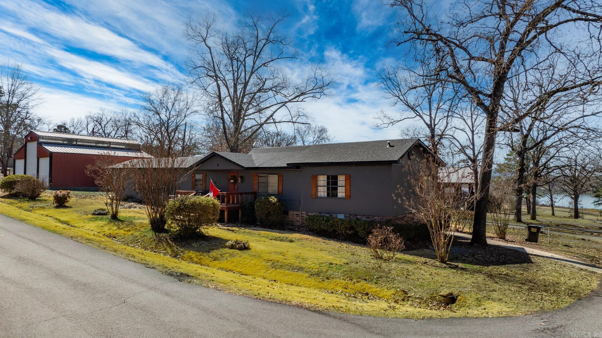 Discover the perfect lake retreat in the heart of Higden! This fully furnished 4-bedroom, 2-bath home offers a spacious split floor plan, a cozy living room, and a large sunroom where you can take in stunning lake views. Recent updates include a new roof, HVAC, exterior paint, and shutters, ensuring a move-in-ready experience. Step outside to enjoy the expansive covered patio, perfect for entertaining family and friends. Need storage? The 30x40 shop with electricity and covered boat parking has you covered. Just a short walk to the boat ramp, this home is ideal as a vacation getaway, short-term rental, or forever home. Don’t miss this incredible opportunity—schedule your showing today!