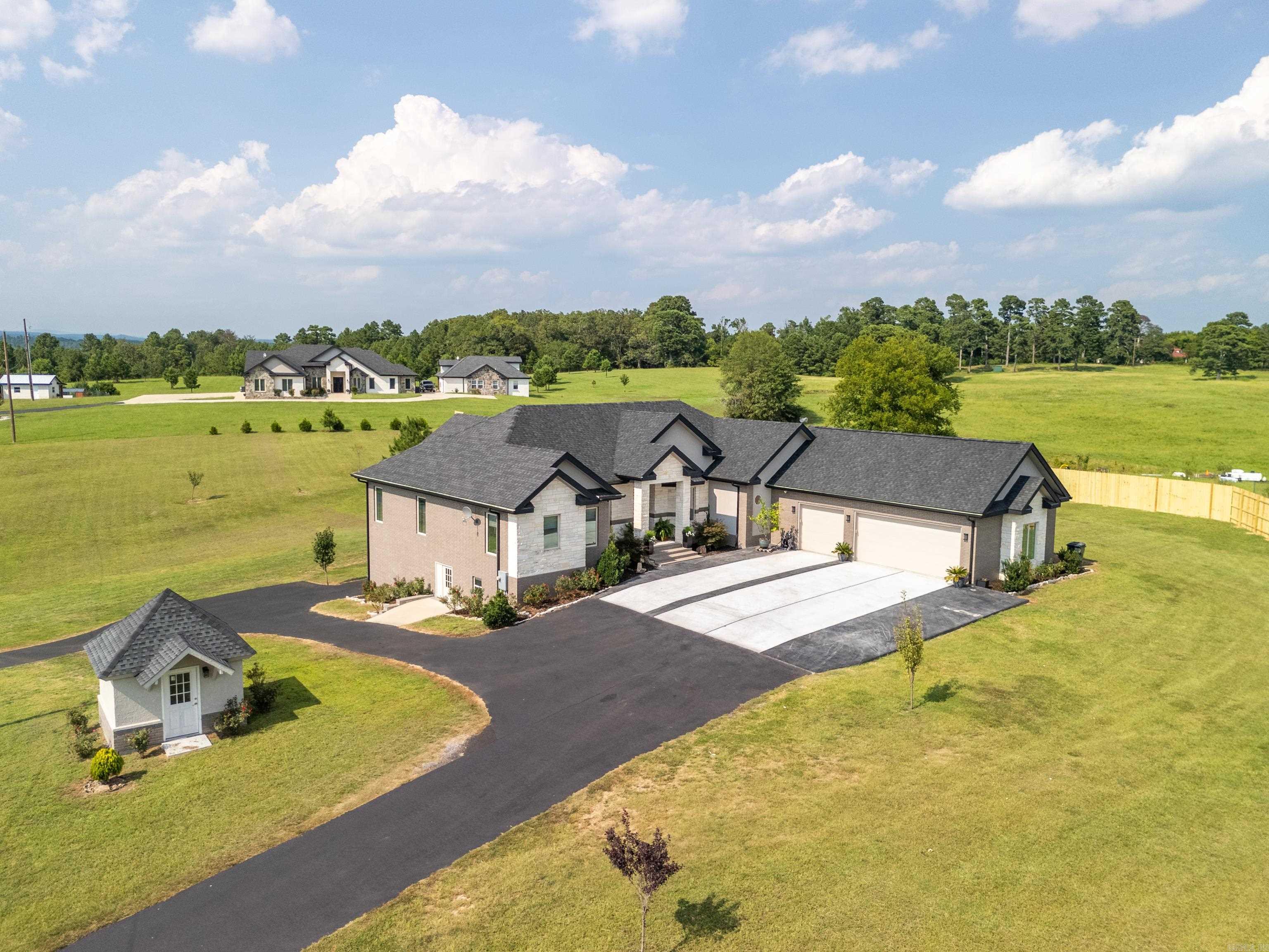 STUNNING HILLTOP RETREAT - 5 BEDROOM 4.5 BATH BRICK HOME ON APPROXIMATELY 3 ACRES WITH BREATHTAKING VIEWS! THIS FABULOUS RESIDENCE OFFERS PRIVACY, SPACE AND PANORAMIC VIEWS. ENJOY THE OPEN LIVING, KITCHEN AND DINING AREAS-PERFECT FOR ENTERTAINING AND FAMILY GATHERINGS. A COOK'S KITCHEN EQUIPPED WITH BEAUTIFUL CABINETRY, A GENEROUS BREAKFAST BAR, SHIMMERING QUARTZ COUNTERTOPS, AND A PANTRY MAKE MEAL PREP A DELIGHT. A LUXURIOUS MASTER SUITE WITH TRAY CEILINGS, AMBIANCE LIGHTING, AND A SPECTACULAR BATH WITH HUGE WALK IN SHOWER, FREESTANDING TUB, AND HIS AND HER CLOSETS. GREAT OFFICE WITH A MURPHY BED. DOWNSTAIRS OFFERS ANOTHER COMPLETE KITCHEN, DEN/PLAYROOM, 2 BEDROOMS AND A BATH THAT ALSO IS A STORM SHELTER, THE DOWNSTAIRS SPACE WOULD BE A GREAT MOTHER-IN-LAW QUARTERS THOUGHTFULLY DESIGNED FOR COMFORT, CONVENIENCE AND VERSATILITY. EXPANSIVE COVERED DECKS FOR OUTDOOR ENJOYMENT AND OUTDOOR DINING, 3 CAR GARAGE WITH EPOXY FLOOR, PLENTY OF SPACE TO GARDEN. THIS HILLTOP PROPERTY COMBINES ELEGANCE, FUNCTIONALITY, AND OUTDOOR LIVING IN A SERENE SETTING. WHETHER YOU ARE RELAXING ON THE DECKS OR EXPLORING THE LUSH ACREAGE, THIS HOME IS A TRUE SANCTUARY. TRULY AN EXCEPTIONAL HOME!