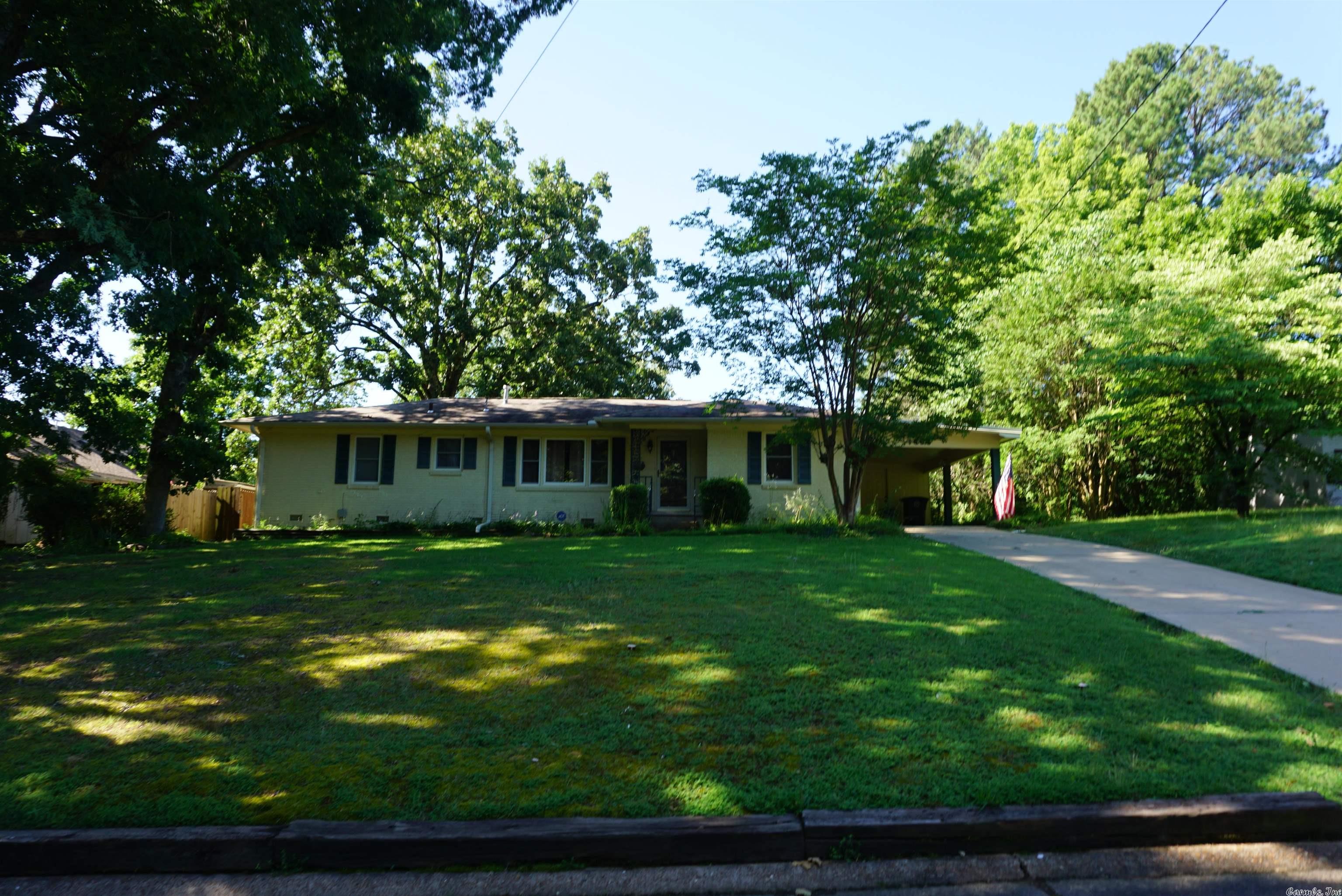 Very well cared for home in Sunny Hill Addition. House has a large living room with a huge picture window Beautiful hand scraped hardwood flooring throughout except bathrooms. Nice size Kitchen has a built in hutch, built in trash cabinet, and nice appliances. There is a huge dining room off the kitchen that could also be a 2nd living room or another bedroom. There are lots of storage in this home. Large laundry room with shelving for additional storage. There is a storage room on the front and another in back of the carport. Fenced back yard is very nice with a large back deck and nice concrete patio and a nice storage building that has a new roof on it. House has gutters and storm doors. House has been replumbed underneath in the last few years. The sellers put in wonderful tilt in insulated windows and the gas water heater was replaced in 2019.