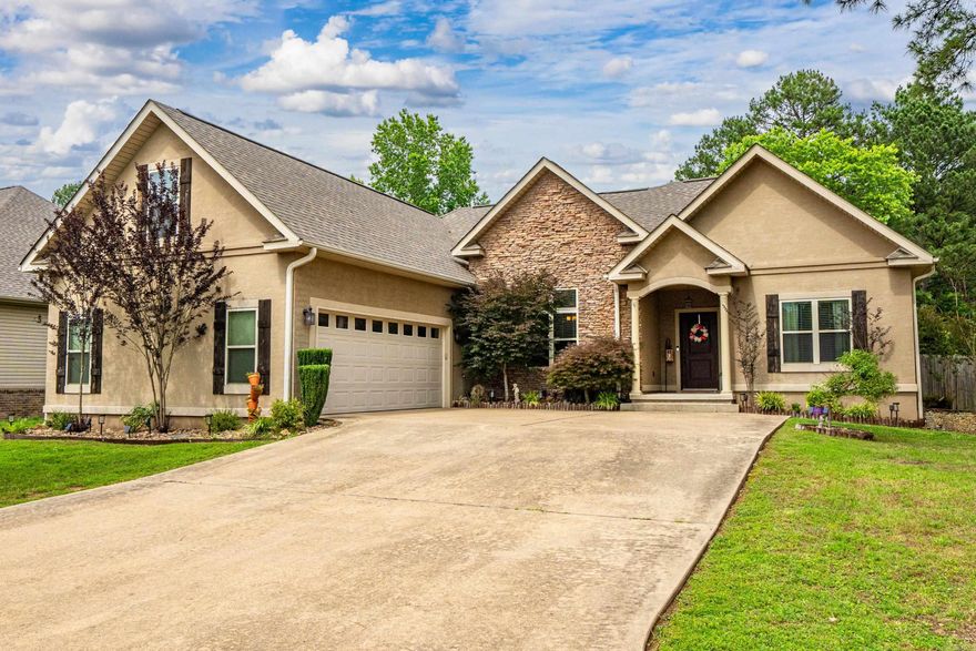 Introducing 282 River Mill — a charming 4-bedroom, 3-bath stone and stucco home tucked in a quiet cul-de-sac in a peaceful neighborhood. Built in 2011, this 2,257 sqft home blends comfort and style with tray ceilings, granite countertops, and a spacious kitchen featuring stainless steel appliances, built-in lazy Susans, and a pantry. The master suite offers a walk-in closet and Jacuzzi tub, while the upstairs bedroom with its own full bath and walk-in closet is ideal for guests, teens, or a private office. Enjoy a fully fenced yard with an additional lot behind the home, plus recent updates like new shutters, soffits, window screens, and a newer roof. Cozy up by the wood-burning fireplace in cooler months and take in beautiful lake views year-round. Located in the Lake Hamilton School District with an EV charging port in the garage and just 10.9 miles from Lake Ouachita — this home has it all.
