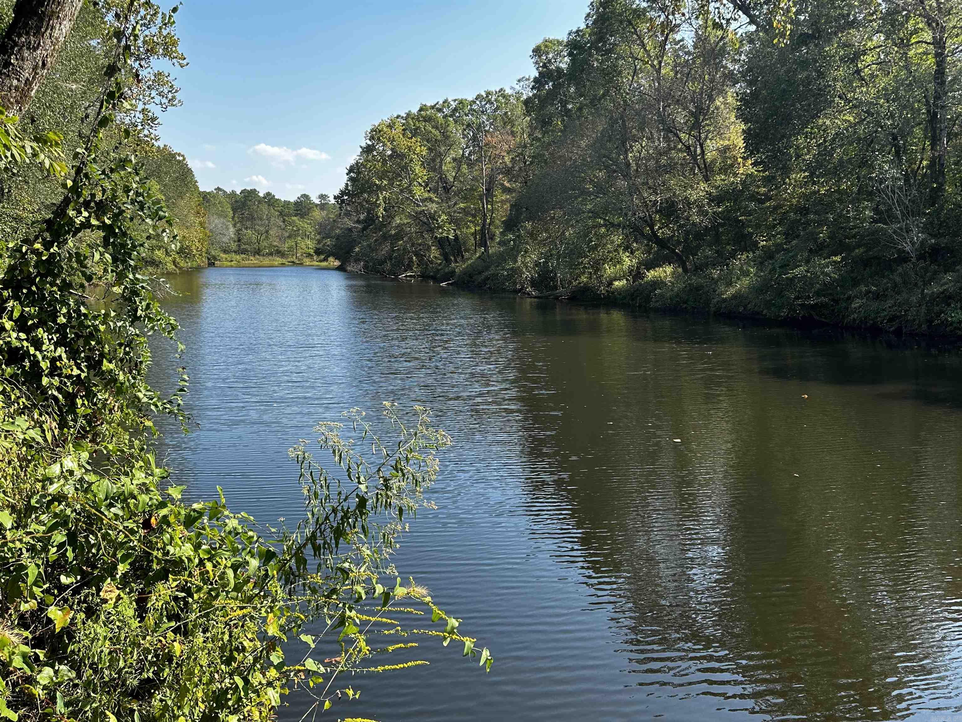 This lot has 228 feet of beautiful River frontage.  Reva's Retreat is surrounded by the National Forest and Irons Fork Creek, 1 mile N of Lake Ouachita + 2 mi. from Launching ramp.  The beautiful 100 acre development offers seclusion, unblemished, back-to-nature, spacious lots - water frontage & River access w/some restrictions, incredible views, and underground electric.  Fishing, kayaking, swimming, nature walks + trailhead for hiking are nearby, as well as amenities at HSV & Mt. Ida. Every day is a vacation.