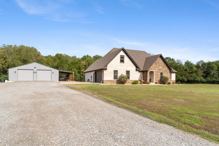 Tucked at the end of a long, private, tree-lined drive, this gorgeous 4-bedroom, 2 full bath, 2 half bath home offers modern design, thoughtful details, and peaceful country living on 6.81 acres. Inside, the open-concept layout features an electric fireplace, leathered granite countertops, a hidden pantry, and pull-out spice racks—perfect for both everyday living and entertaining. Each bedroom offers generous closet space with built-in pull-out drawers, while the large laundry room includes a sink, folding counter, and pull-out hamper cabinets for maximum convenience. The split-bedroom design ensures privacy, and the spacious upstairs bonus room with its own half bath offers endless possibilities as a guest suite, home office, or game room. Step outside to enjoy the covered back patio or the additional covered area off the shop, ideal for equipment or outdoor gatherings. The backyard is fenced for pets, leaving the remainder of the property beautifully open and framed by mature trees on three sides. A true standout, the 40x40 heated shop is wired with 240-volt electric, equipped with hard-wired heat, and includes its own half bath—providing endless opportunities.