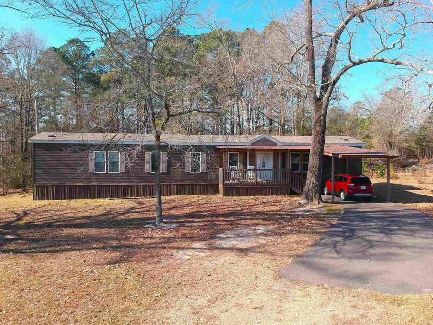 An immaculate one owner 2019 Sunshine mobile home nestled on a quiet 1.89 acre tract, across the road from the Hampton Hollows Subdivision.  This home boasts an open floor plan with a large kitchen/living area. The kitchen has a large island with an eat-in, bistro height bar on one side. All appliances included. Lots of cabinet space and there is also an area for a dining room table.  There are three spacious bedrooms and two bathrooms. The primary bath is complete with a garden tub and separate shower.  Tons of natural light make this 1,280 sqft seem surprisingly spacious!  Wood plank pattern vinyl flooring provides a warm feeling throughout the kitchen/living area with carpet in the bedrooms.  Spacious laundry room with WASHER/DRYER INCLUDED.  Sit on the back porch and enjoy the quiet of country living...not too far from Dollar General!  MINERAL RIGHTS DO NOT CONVEY ON THIS PROPERTY!