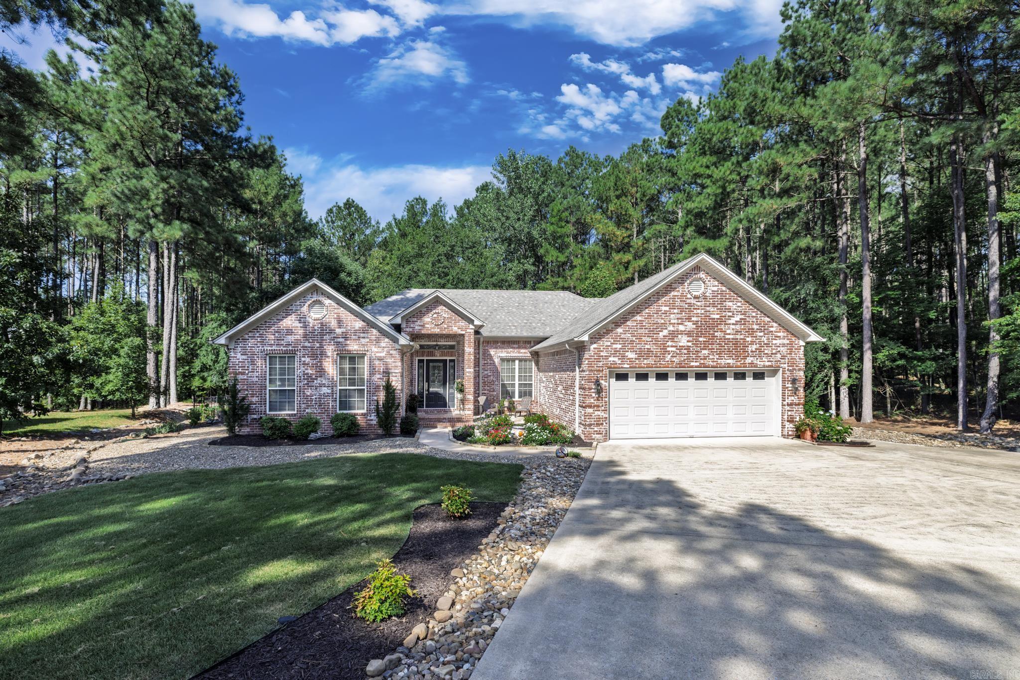 Lovely custom-built home on over half acre in Hot Springs Village! Backing to common property and adjacent to a vacant lot, this beautifully landscaped property offers peace, privacy, and space. The home features a traditional design with a desirable split floor plan, large, bright kitchen with custom cabinetry, double oven, and pantry, plus an oversized laundry/utility room. Recent updates include new flooring throughout, both bathrooms remodeled utilizing granite and quartz, freshly painted interiors, newer roof, water heater, HVAC system, and sprinkler system. Enjoy outdoor living year-round in the expansive screened-in patio overlooking the fully fenced backyard. Lavish landscaping and stonework surround the home, creating a serene setting inside and out. A truly move-in-ready home in a tranquil locationādonāt miss this one! Agents see Associated Docs for more updates.