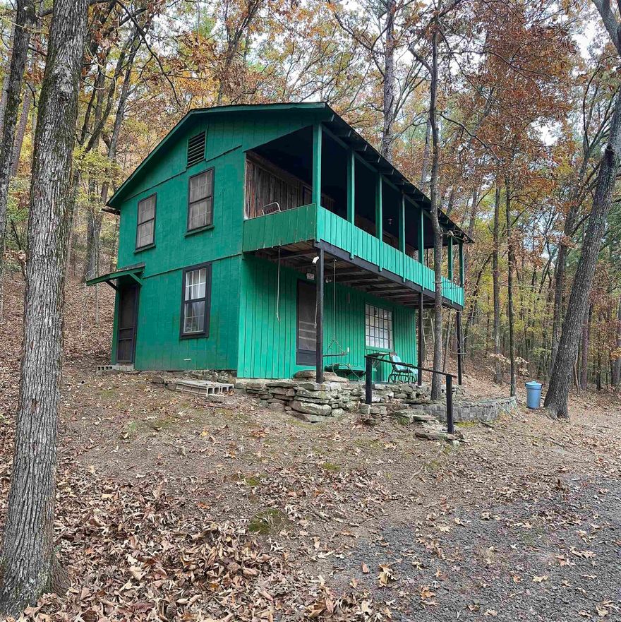 Escape to the quiet of Cove Creek in this rustic, two-story cabin tucked into the trees and just minutes from the lake. Offering 896 sq ft, this cozy retreat is the perfect getaway spot, Airbnb opportunity, or fishing cabin. The main level features a functional kitchen, a comfortable living area, and a small dining nook. Upstairs, you'll find a spacious loft-style bedroom currently set up to sleep four beds comfortably, along with a full bathroom and a charming upper balcony overlooking the woods. Both levels include their own window units for heating and cooling. The cabin is being sold as-is, giving the new owner freedom to update or enjoy exactly as it is. Sellers are also offering a 1 year home warranty. A great opportunity for anyone wanting an affordable lake-area get away!