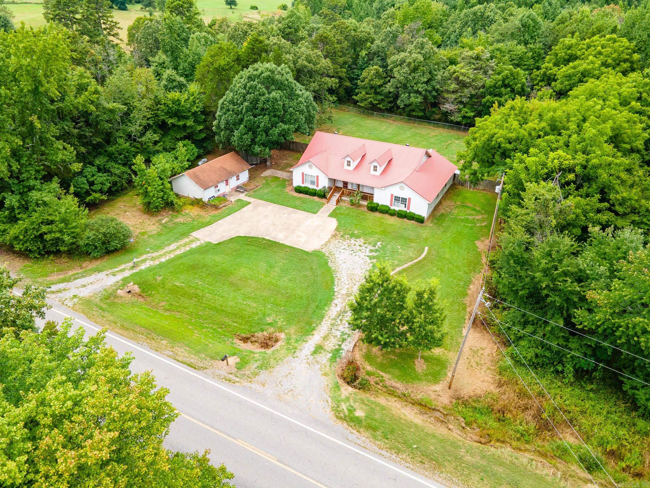 This great home is nestled within the Beebe School District. It's a charming ranch-style home sitting on a spacious 1 acre lot & features a durable metal roof. With 2,800+ sq ft of living space, this home has been recently updated with new flooring, fresh paint, and updated HVAC.The heart of the home has a supersized living room, perfect for gathering and relaxation. The large eat-in kitchen is a culinary delight with island bar seating, pantry, and natural lighting. The primary wing provides a serene retreat with a huge bedroom that offers exterior access, seating area, a garden tub, walk-in shower, vanity, and ample walk-in closets. On the opposite side of the home, you'll find 3 additional bedrooms, a full bath, and plenty of storage. Storage does NOT lack in this house! The remote location, open floor plan, and abundance of closet space is a joy for many families. Enjoy outdoor living with a beautiful wide front porch, And an enclosed patio. PLUS,an 800 sq ft shop or potential in law suite that's already floored, wired, cooled, and has it's own septic tank. Additional features include an outbuilding, storm shelter, dog cover, circle drive, and views of the deer! Call today!