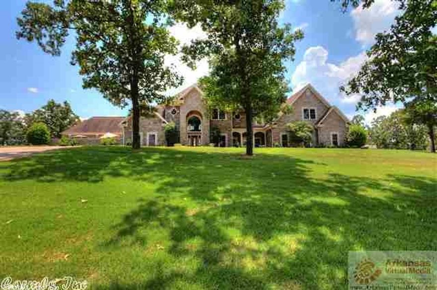View on top of the hill!  Magnificent home with 2 living areas, formal dining, 4 bedrooms, 4 baths, theatre room,kitchen with granite countertops and tons of cabinets, dining room with bay window, fireplace in one living room, circle driveway, brick and rock exterior, gorgeous hardwood flooring, built in bookcases, absolutely to die for master bedroom with patio and master bath, with packing station closets, huge playroom, extensive trim, talls ceilings, recessed lighting,3 car side garage, has it all!