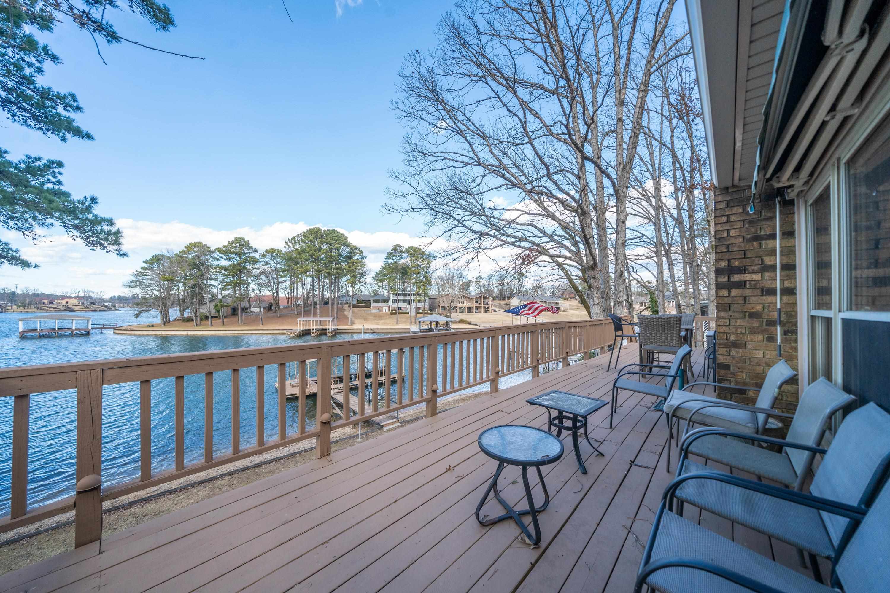 Discover this spacious 2,600 sqft lakefront house located off of Long Island, offering 4 bedrooms and 3 bathrooms across two thoughtfully designed levels. Located on the Lake Hamilton with 100’ of lake frontage, this home is perfect for enjoying serene water views and a laid-back lifestyle. The main floor features 2 bedrooms, 2 bathrooms, and an inviting living area with a cozy woodburning fireplace. Entertain in style with two dining spaces and a well-equipped kitchen. Step out onto the expansive upper deck to soak in breathtaking lake views. Downstairs, you’ll find 2 additional bedrooms, 1 bathroom, and a large den with another woodburning fireplace and wet bar. The lower level also includes a convenient laundry room and access to the patio, where you have additional access to the outdoor living. Relax by the water, enjoy your 1-stall boat dock, or take a refreshing dip from the swim platform. *New roof 2023