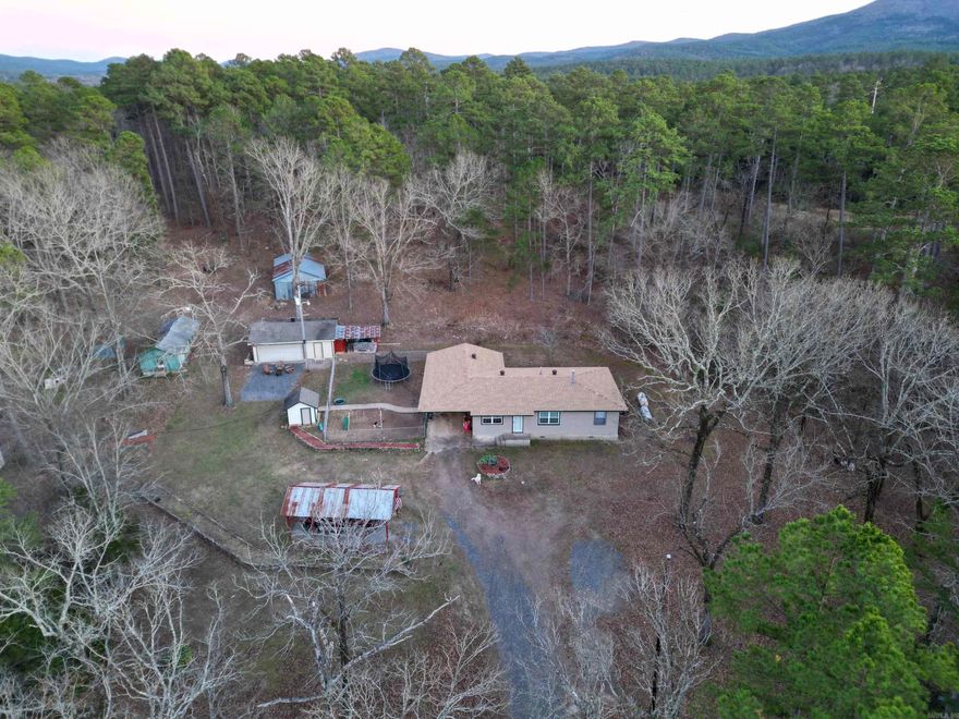 Abundance of wildlife on this beautiful 6.02 acres. Ride straight to Fourche Mountain ATV trails! This property features a beautiful pond fully stocked, with a 22x30 shop with electrical. Several barns, outbuilding and two carports for extra parking, plus one is large enough for and RV or a camper. House has 3 bedrooms currently and an extra bonus room to be used as a 4th bedroom. The current bathroom has totally been renovated with all new upgrades. Roof is less than 5 years old, and a new chain link fence has been added. Survey of property is on file. Call for showings. Agents see remarks.