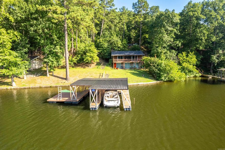 Welcome to your perfect lake escape! This beautifully maintained lake home on the shores of Lake Hamilton offers the ideal setting for year-round waterfront living, weekend getaways, or an unforgettable family retreat. One of the standout features is the private 2-stall covered boat dock, complete with an attached swim dock, making it effortless to enjoy everything the lake has to offer. Whether you're boating, swimming, fishing, or simply relaxing by the water, this setup is ideal for entertaining kids, grandkids, and guests alike. Inside,the home blends comfort with opportunity. The updated kitchen provides a modern touch with refreshed finishes, making meal prep easy whether you're hosting a summer barbecue or cozying in for the weekend. The home has been well-maintained over the years and is move-in ready, while still offering the chance to add your own personal style and updates. But what truly sets this property apart is the expansive lake view — whether you're sipping coffee on the deck, enjoying dinner at sunset, or unwinding after a long day, the view is simply breathtaking.